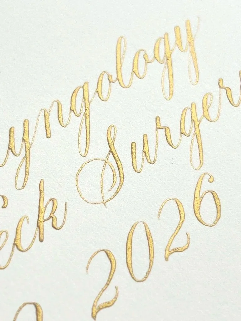 Close-up of gold calligraphy text reading "happy..." and part of the year "2026" on a white background.