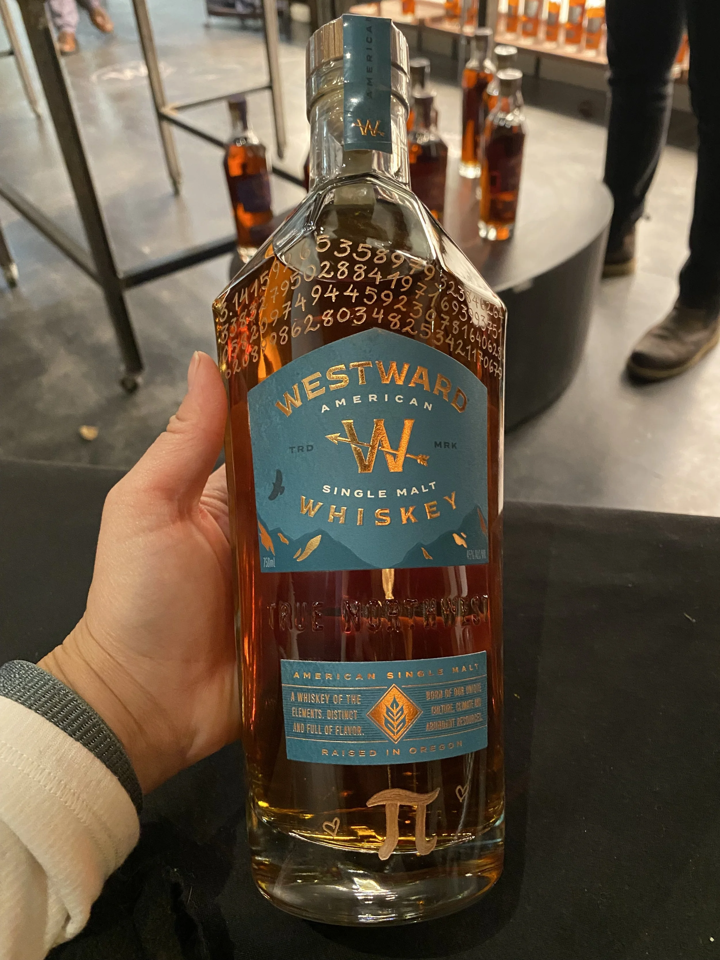 Westward whiskey bottle engraved with the numbers of pi and pi symbol at the bottom
