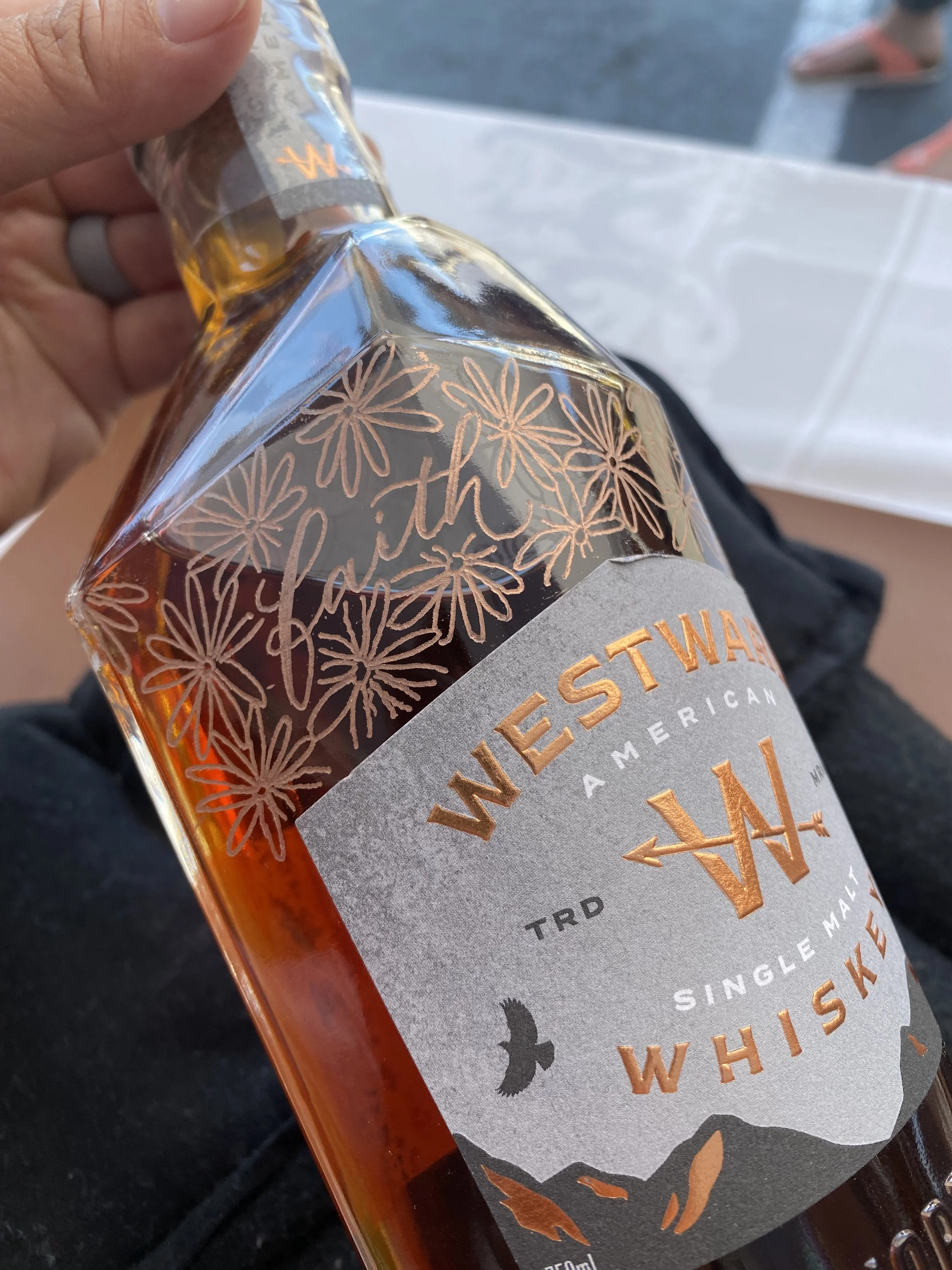 Engraved Westward Whiskey bottle decorated with daisies and the word faith