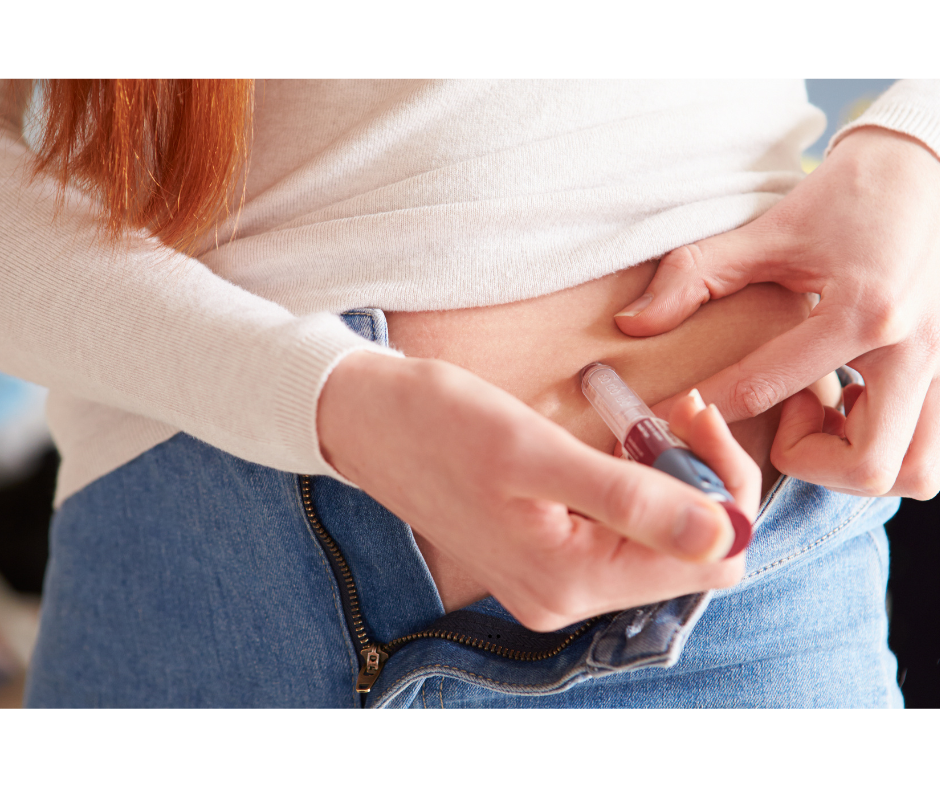Person injecting insulin into their abdomen.