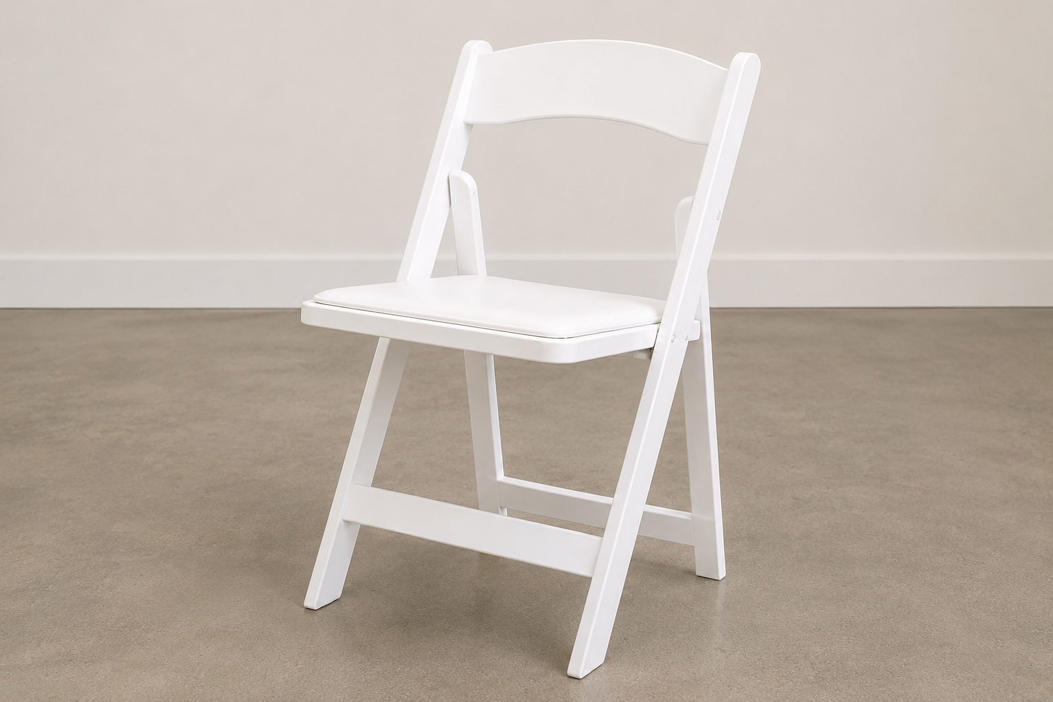 White folding chair on beige carpet in front of a light-colored wall.