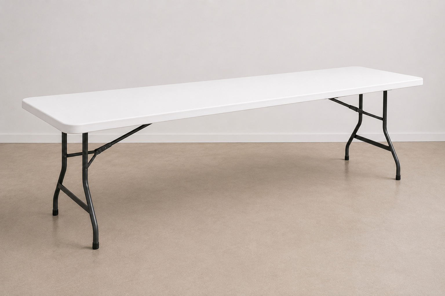 White folding table with black metal legs in a room with beige carpet and plain white wall.