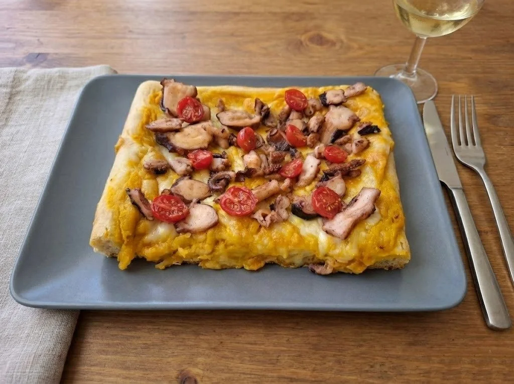 Pizza con crema di zucca, polpo caramellato e pomodorini confit