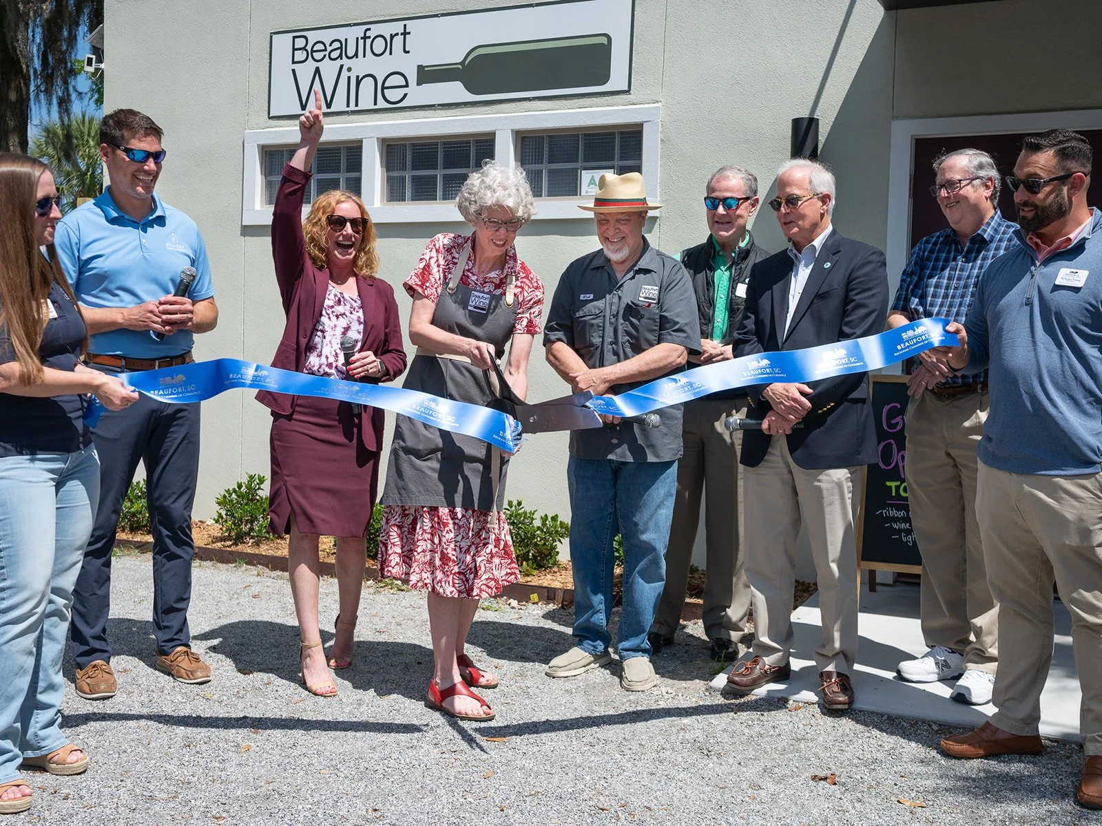 Local Beaufort business owners cutting a ribbon at the Beaufort wine shop.