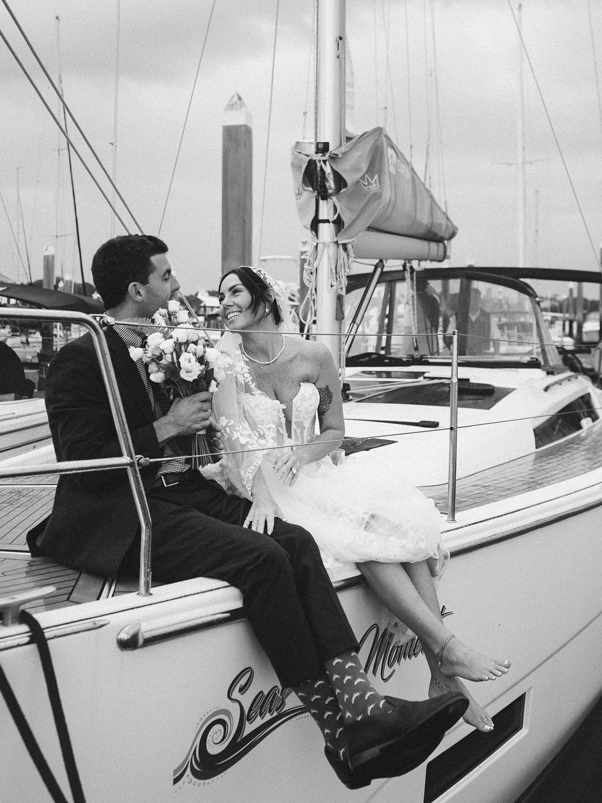 Bride and groom toasting with champagne on the deck of a sailboat at sunset on the Beaufort River.