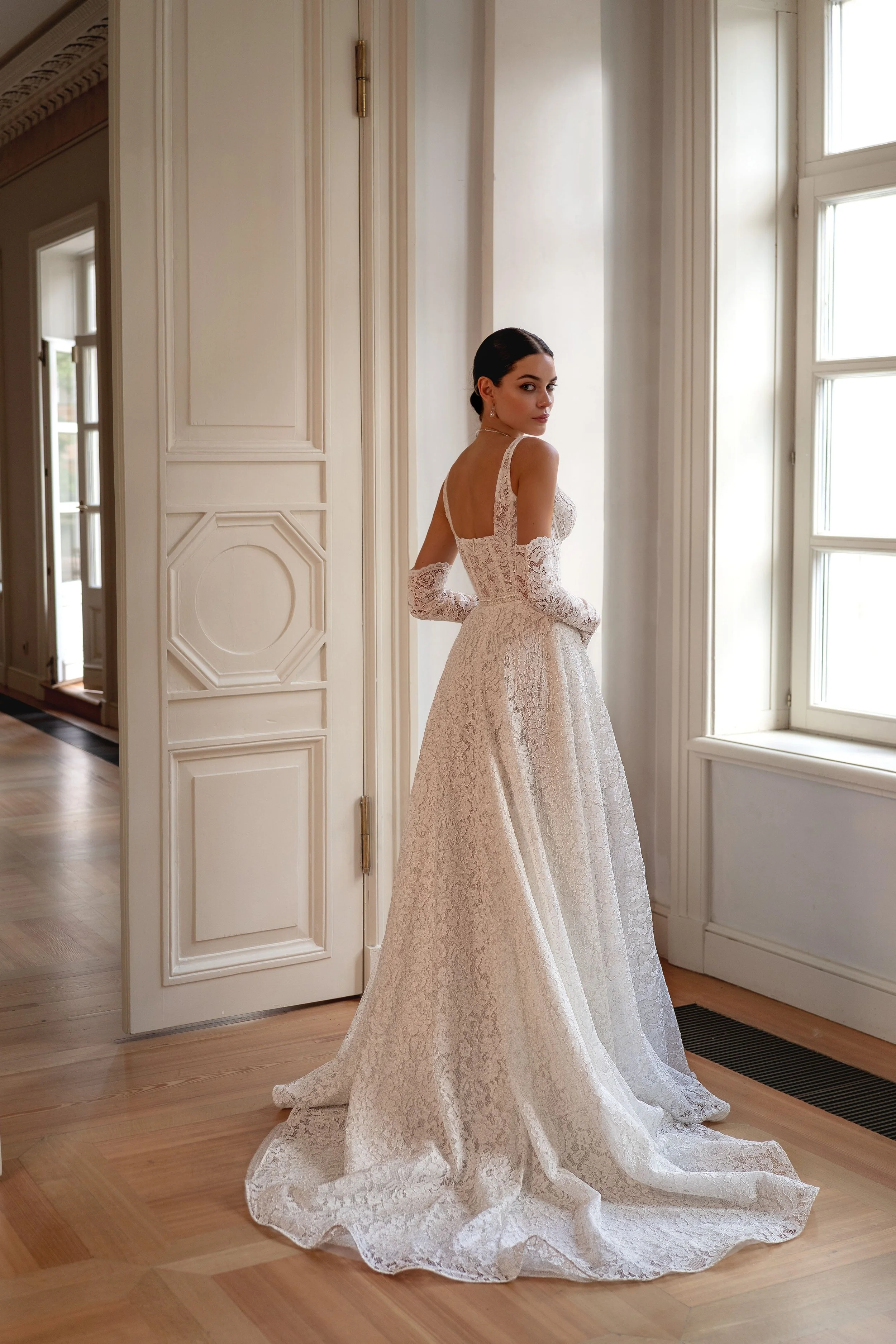 Elegant back view of the Kapris gown, highlighting the continuous lace pattern and delicate gloves for a cohesive bridal look.