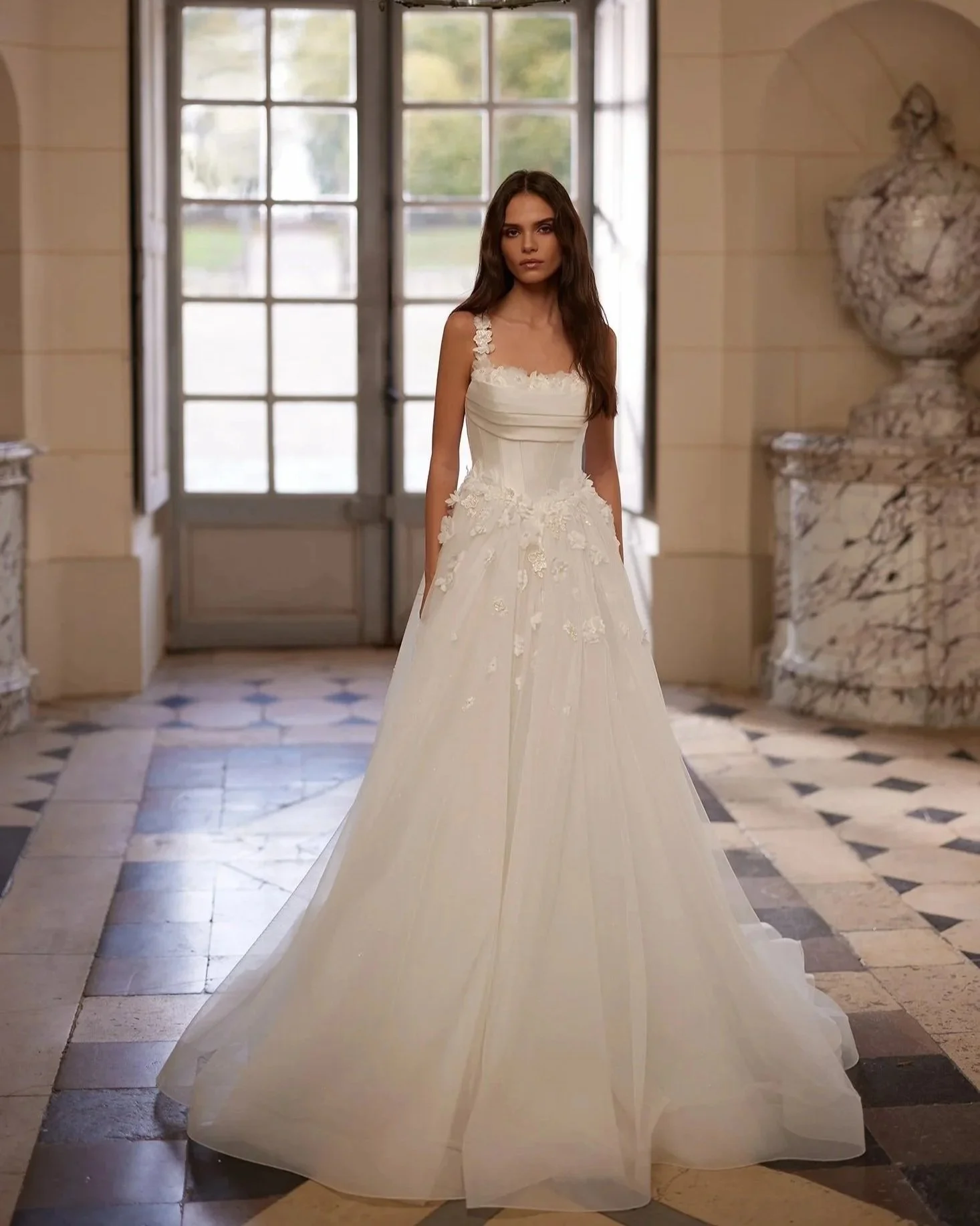 A bride in Snow by Aria, A modern A-line silhouette, with a basque waist, 3d florals and tulle skirt.