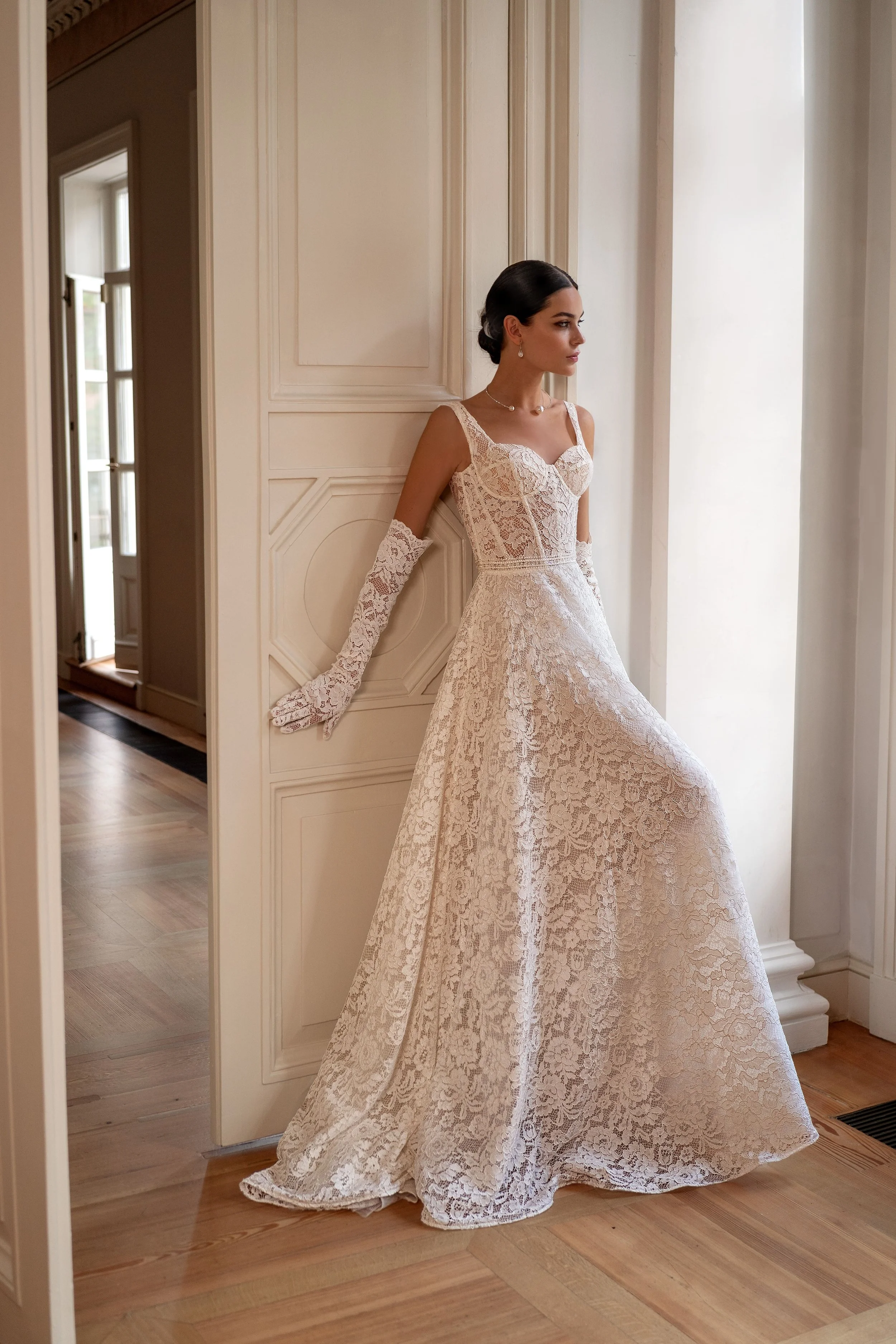 Front view of the Kapris wedding dress, featuring all-over lace and matching lace gloves