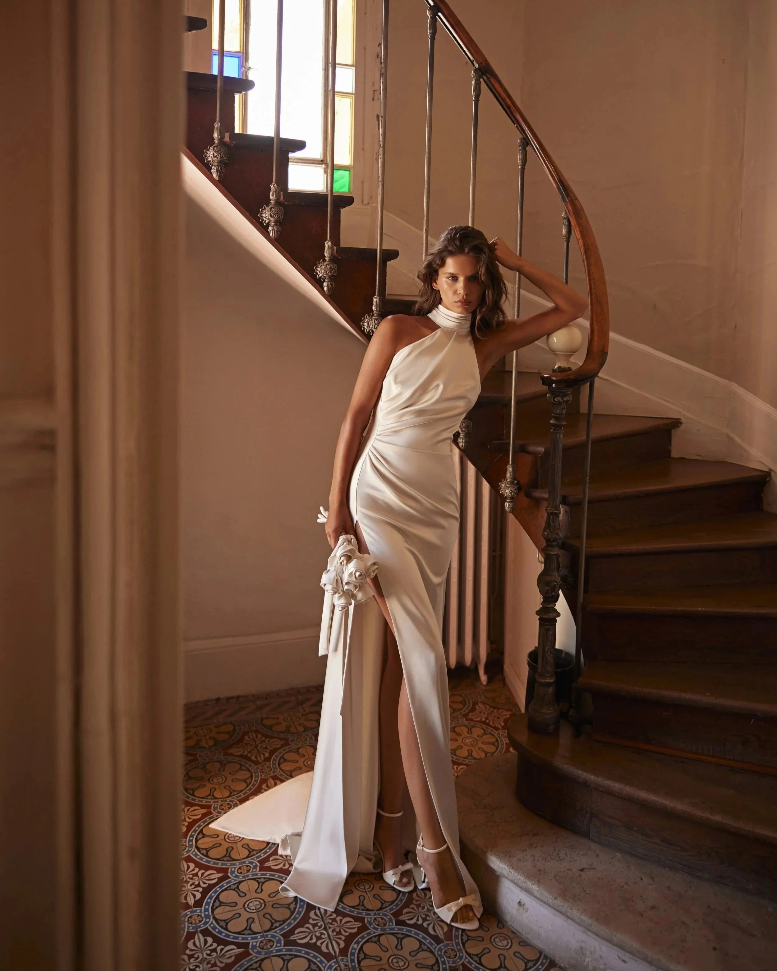 Ethereal Bridal gown by Luce Sposa, a halter neckline in luxurious satin. Sheath silhouette with a slit.