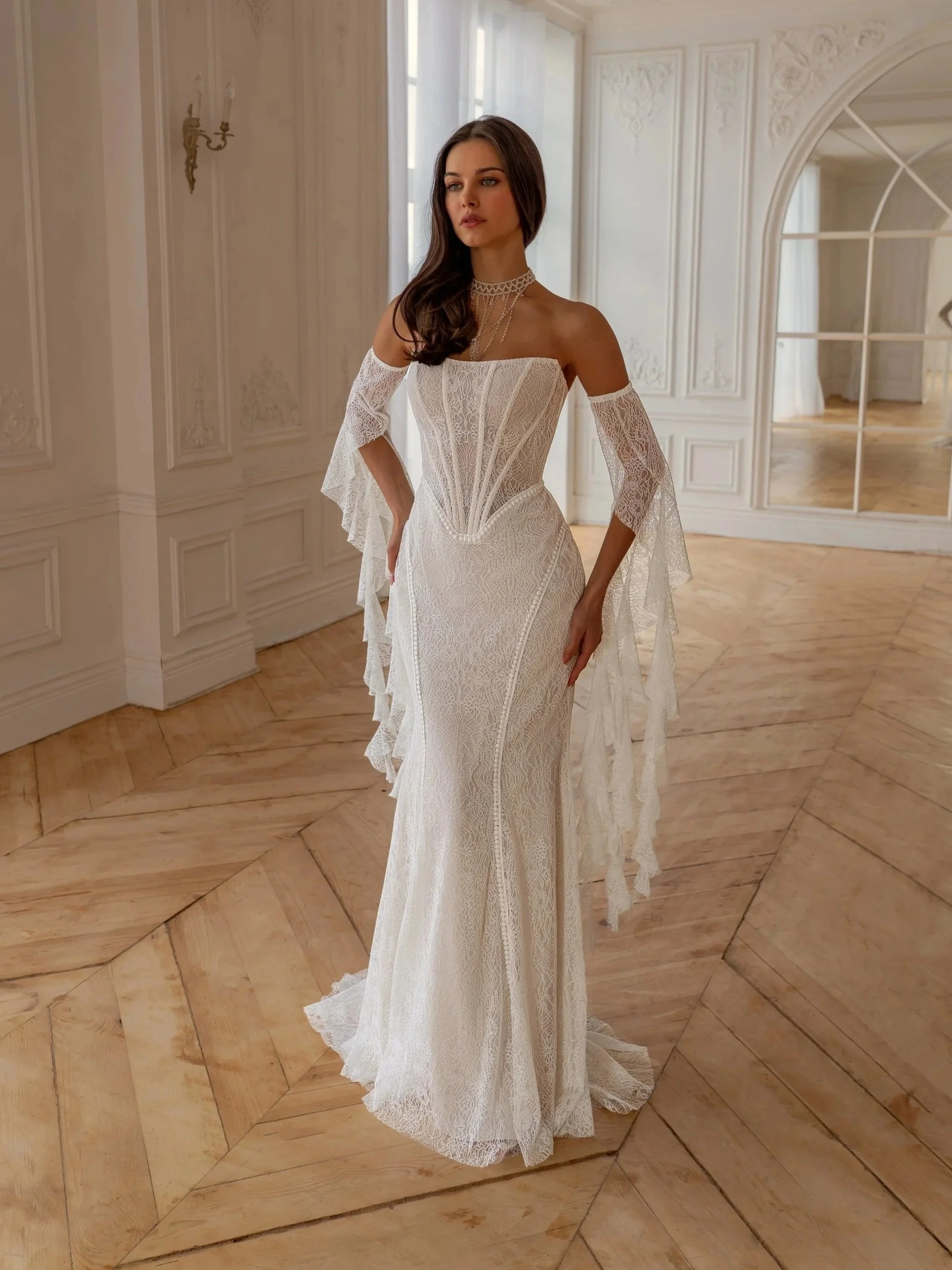 Tatiana Kaplun Starla, an all-over lace fit-and-flare gown with a sheer corset bodice and draped lace sleeves
