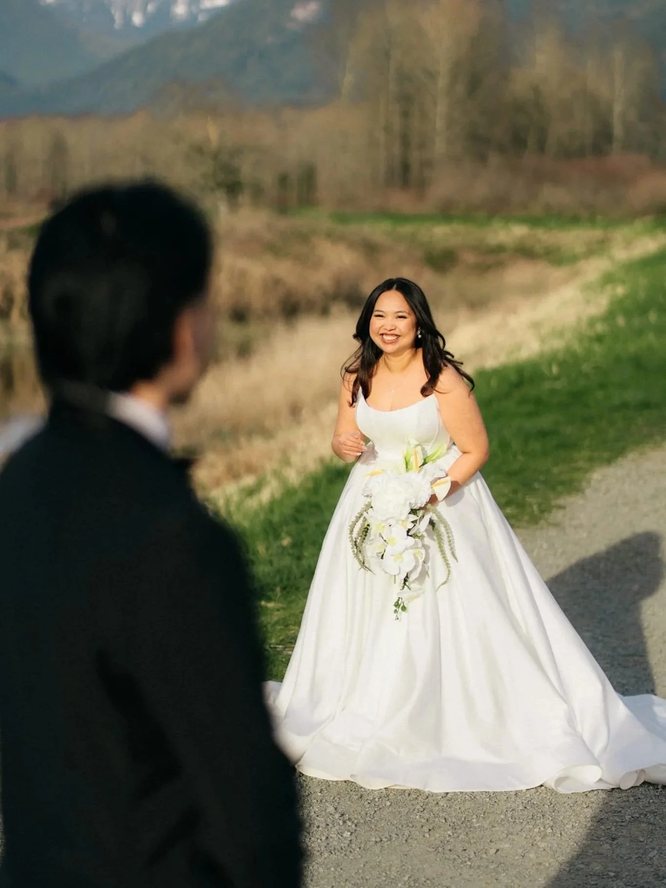 Bride in the Adell scoop-neck satin ballgown by Kira Nova during a first look in a mountain meadow