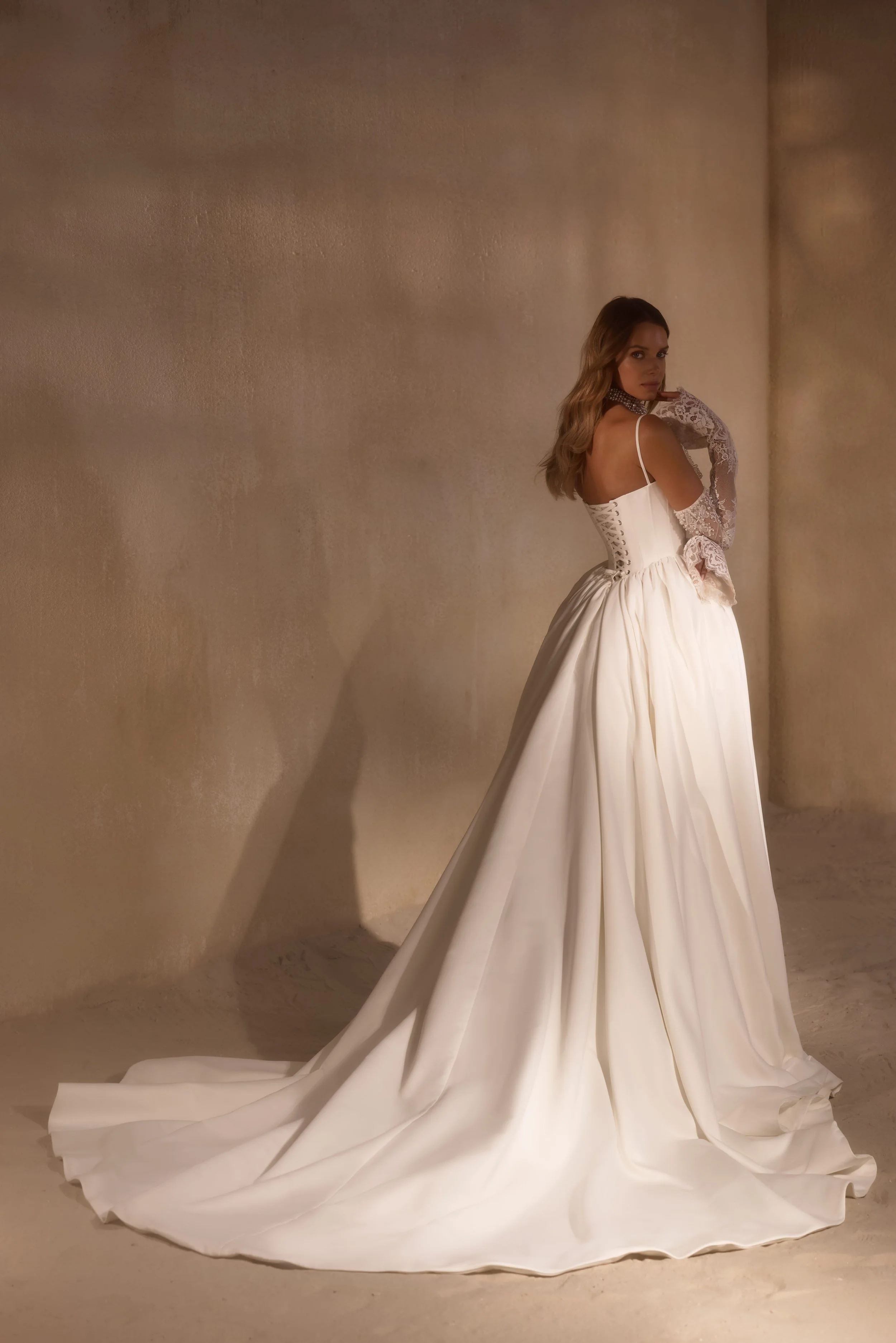 Lace-up back nude sheen wedding gown with flowing polka-dot mesh skirt, pearl and crystal embellishments, and velvet Chantilly lace overlay.