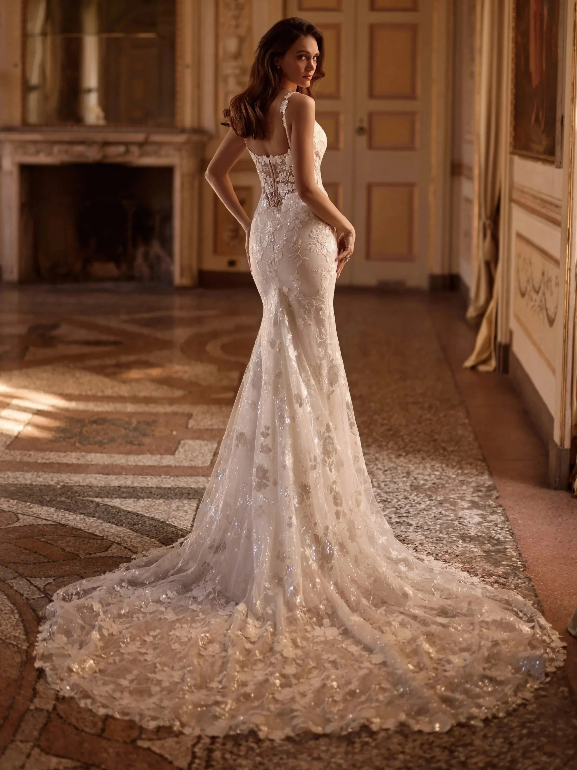 Mirel gown by Ari Villoso seen from behind: sequined floral-lace fit-and-flare with a sheer corset back and long train