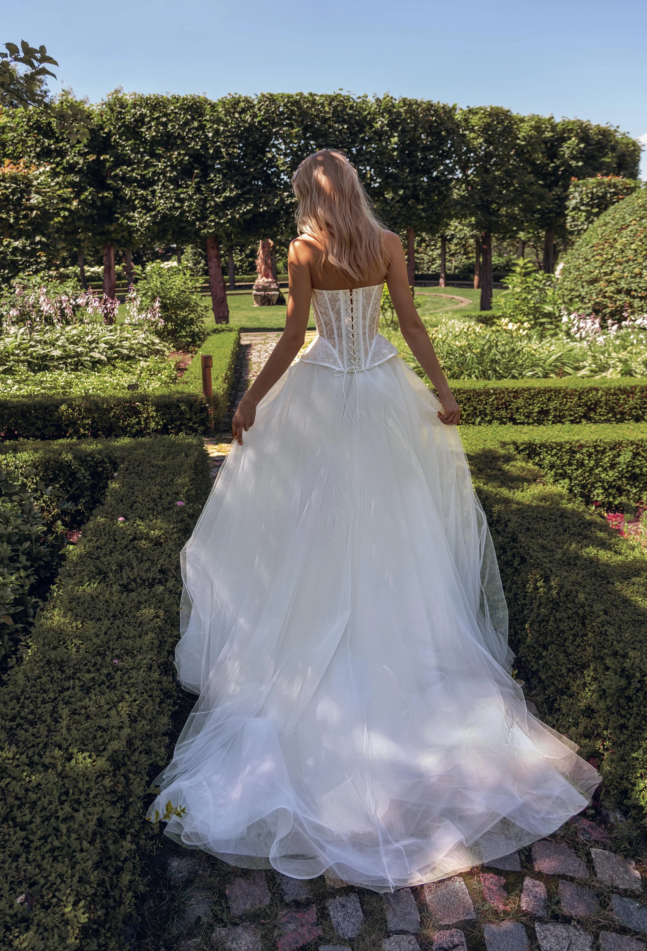 Back view of the Gvendolin two-piece wedding dress with flowing tulle skirt and lace corset.