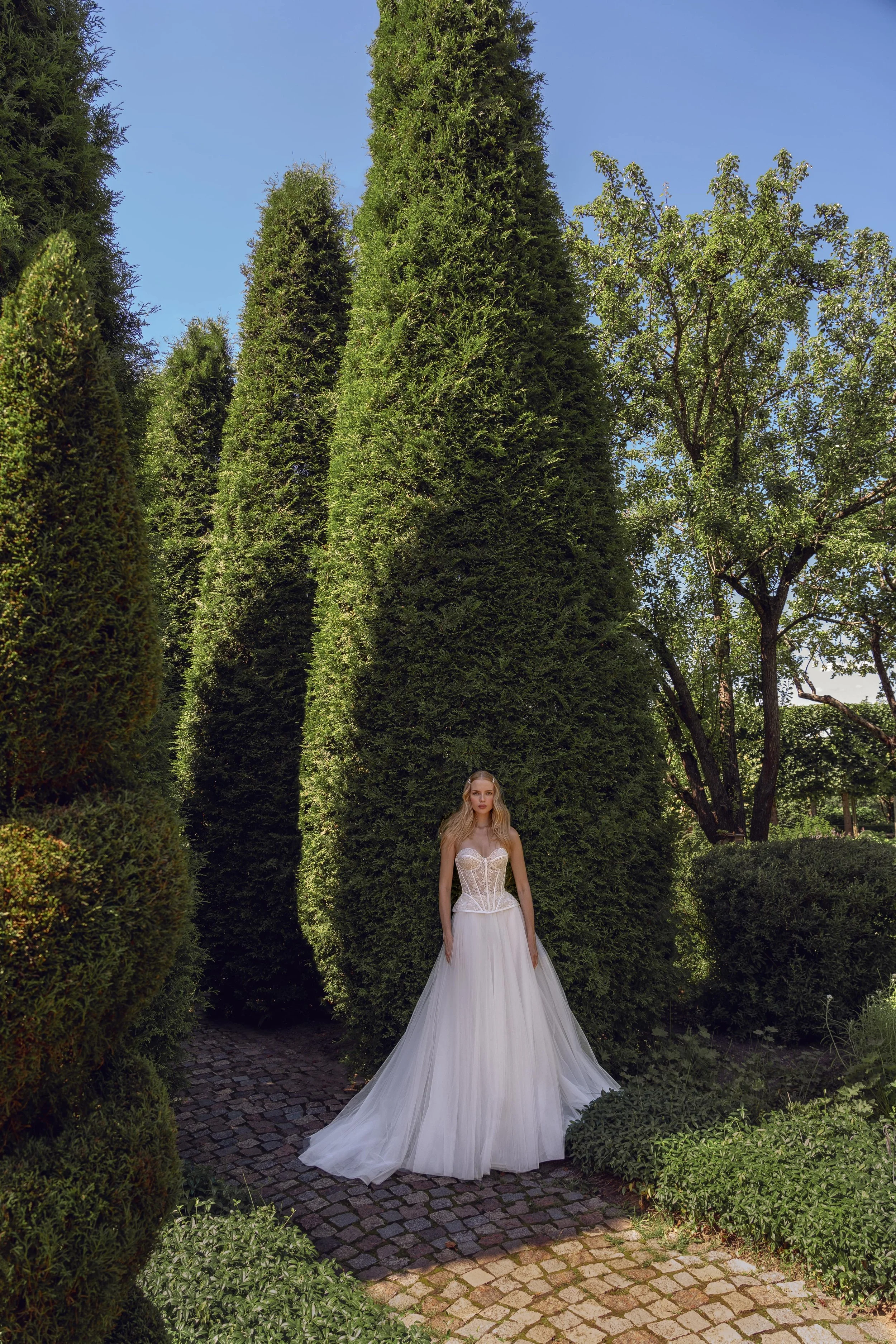 Model wearing the Gvendolin wedding dress, front view showing tulle skirt and lace corset.