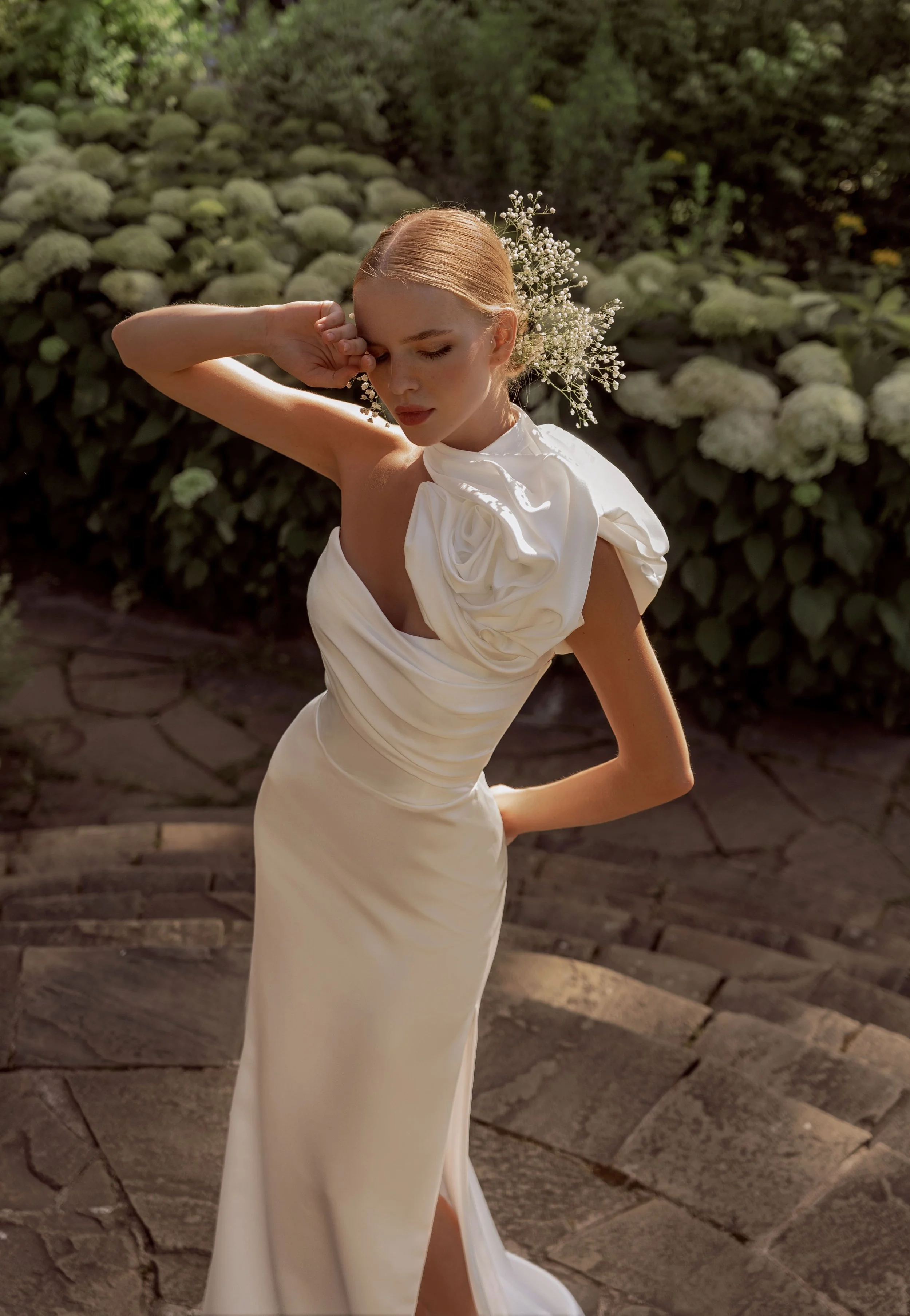 Close-up front view of the Brenda wedding dress in luxurious satin with asymmetrical neckline and statement floral bolero.