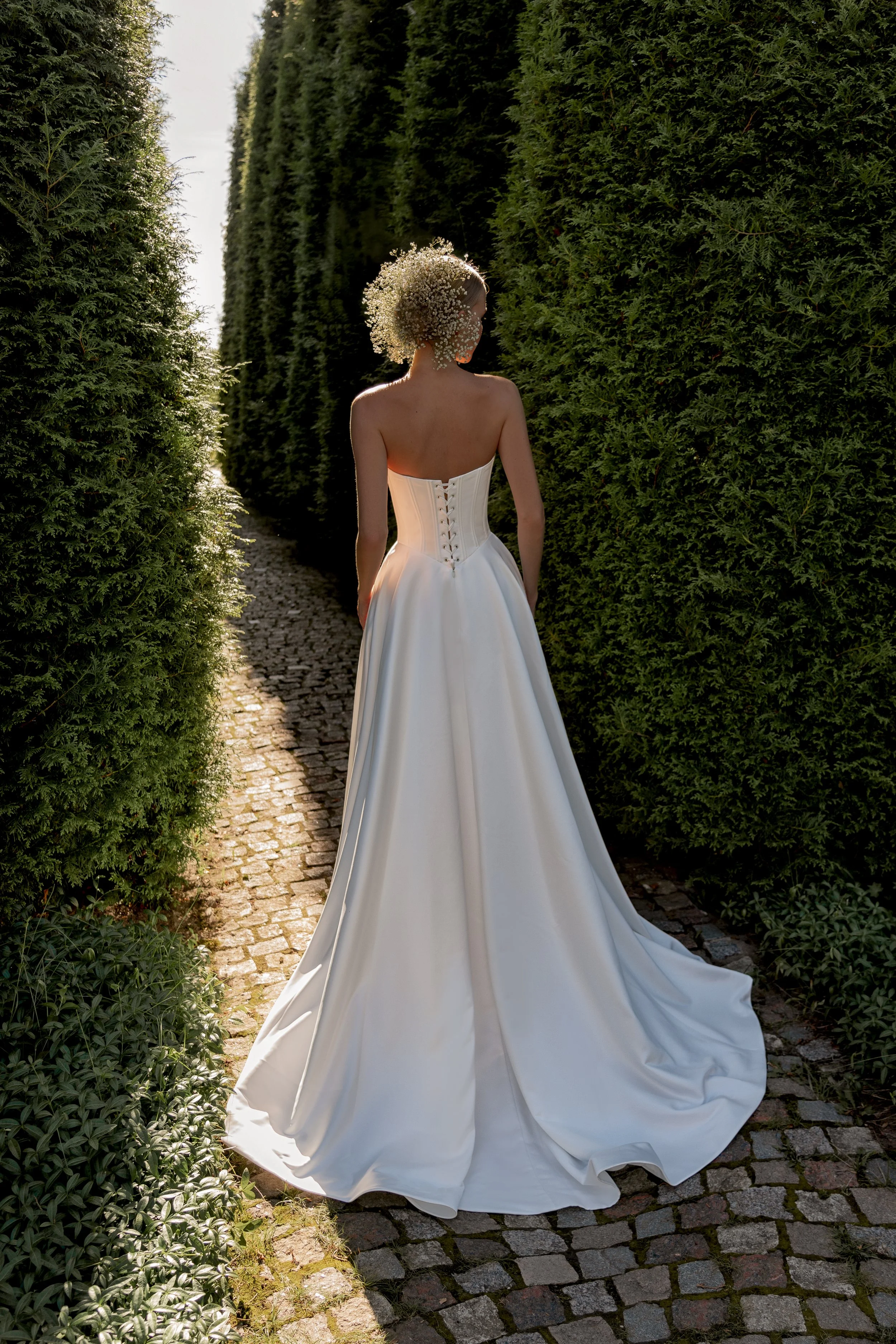 Back view of Sanlar bridal gown showcasing the satin corset closure and flowing A‑line skirt.