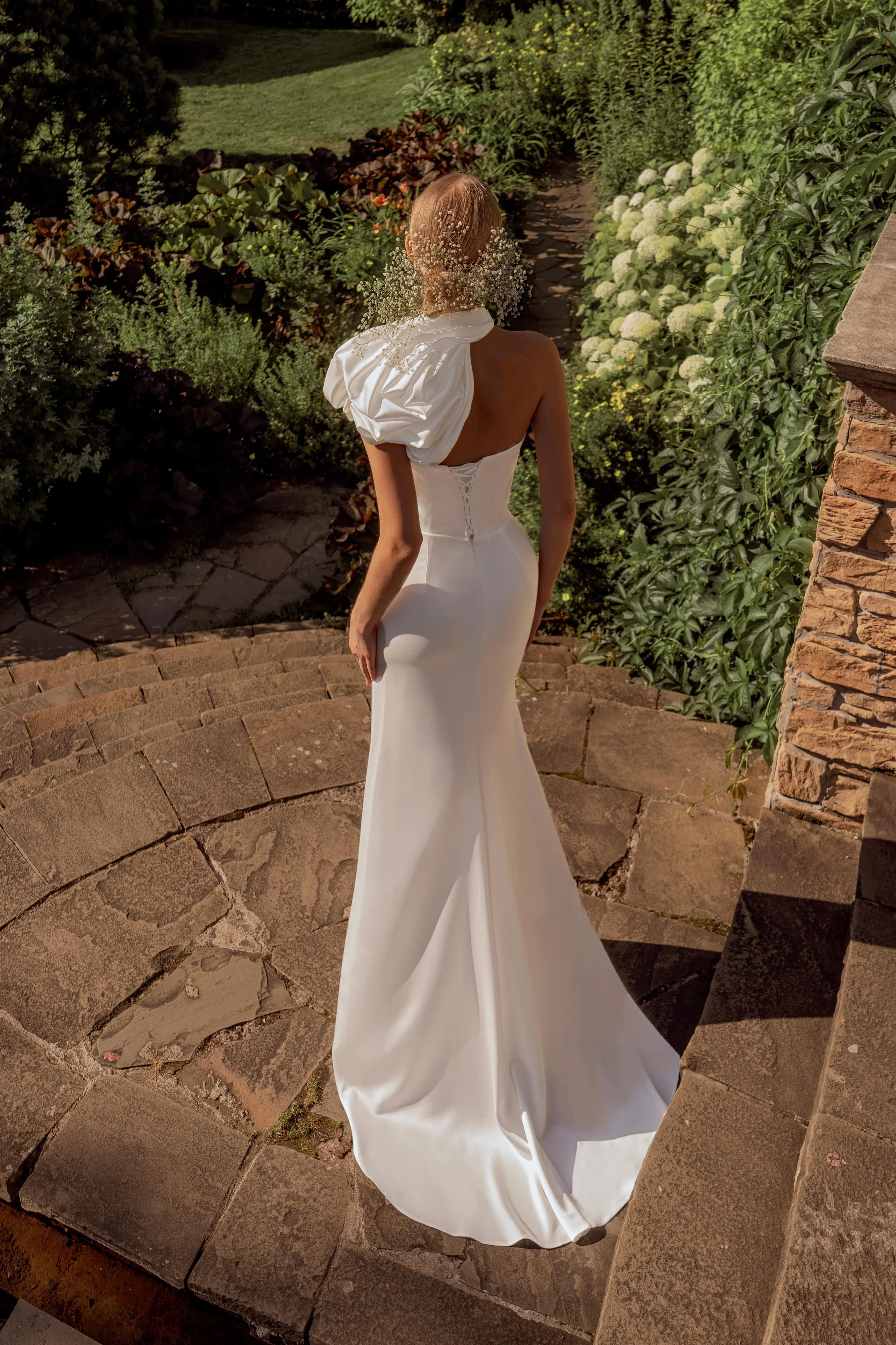 Elegant back view of the Brenda gown, showing the smooth satin column silhouette and the striking statement floral bolero.