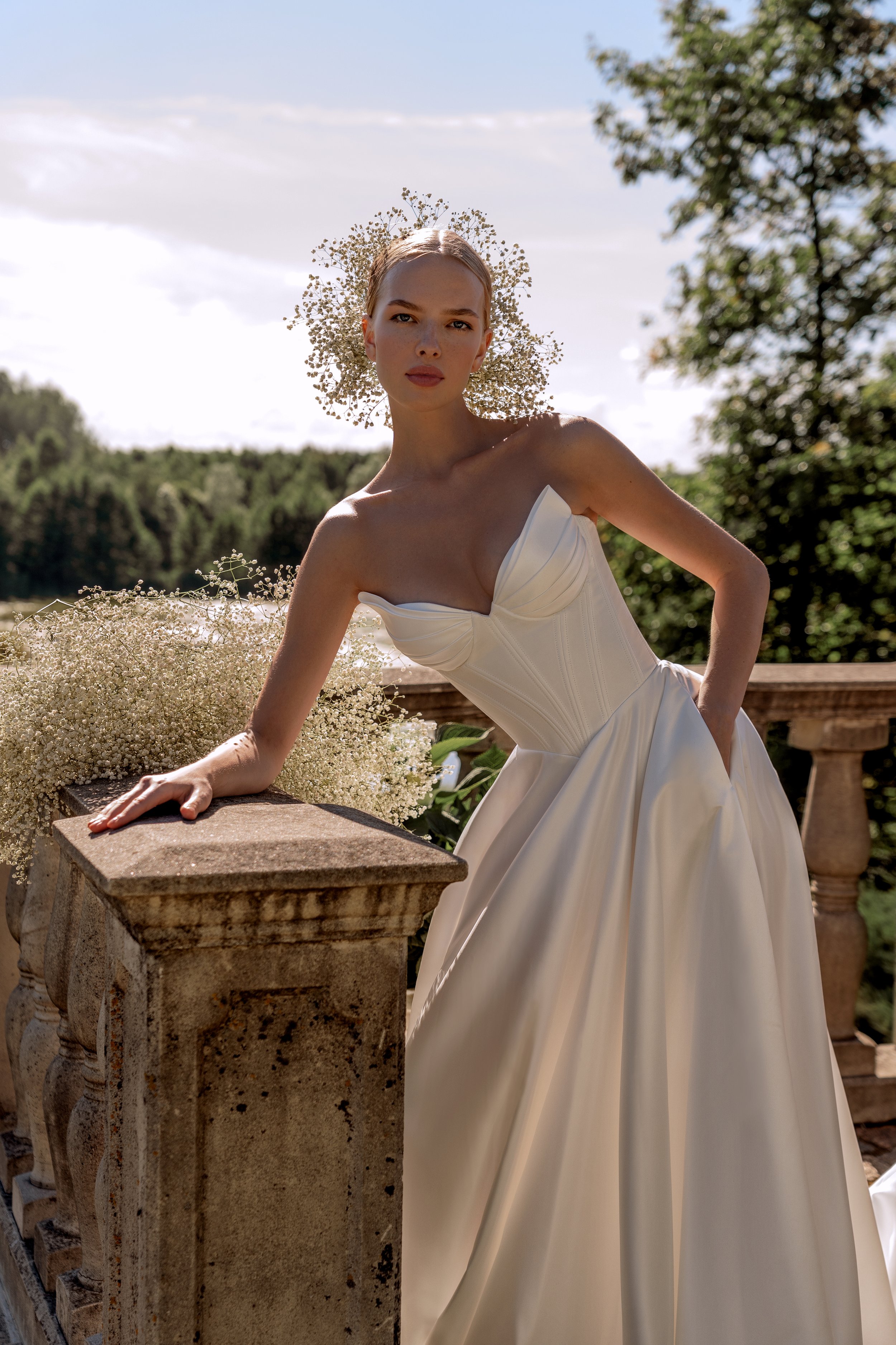 Close‑up of peaked neckline detail and satin fabric texture on Sanlar wedding dress.