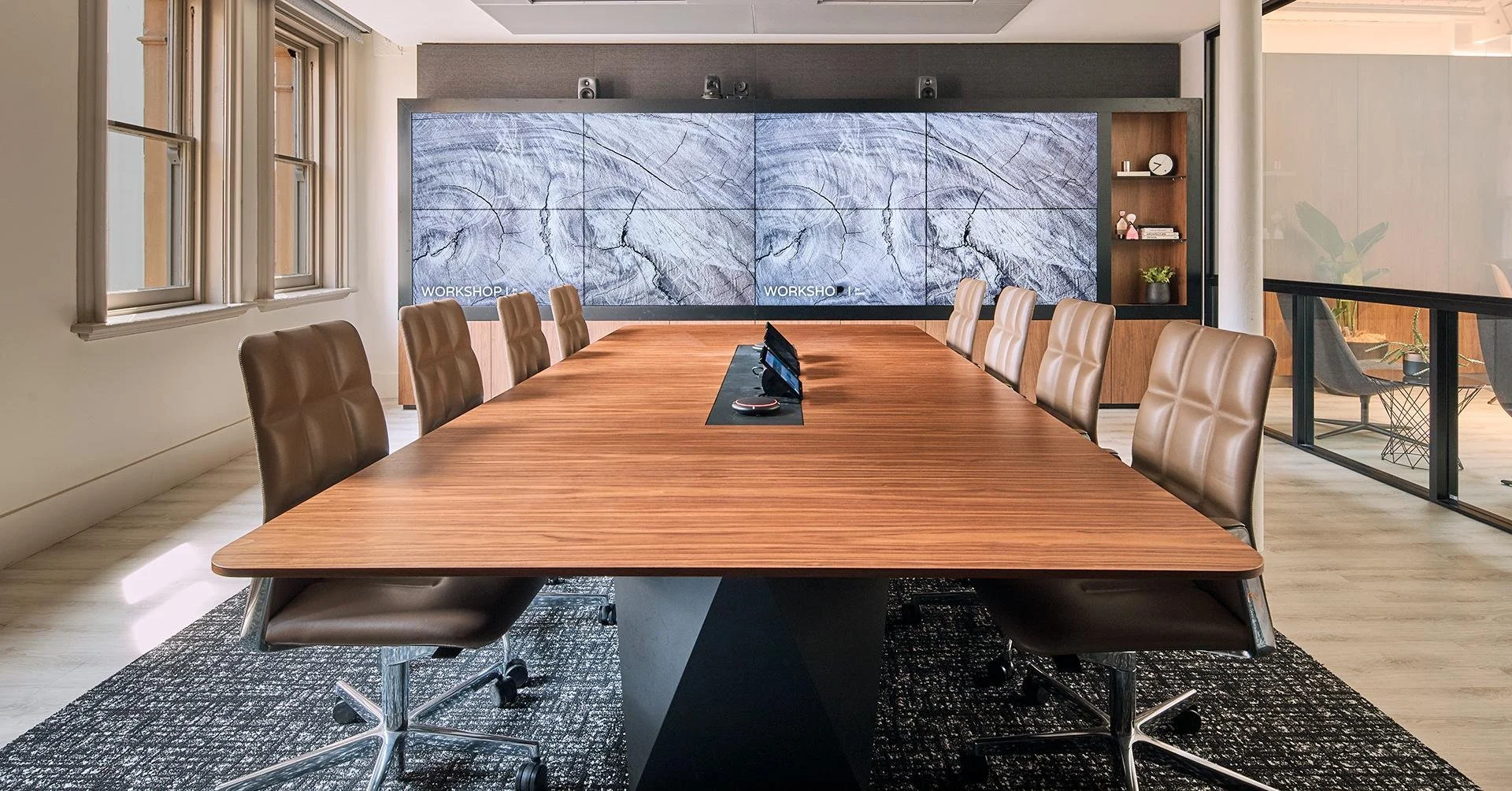 Modern boardroom with conference table and digital display screens