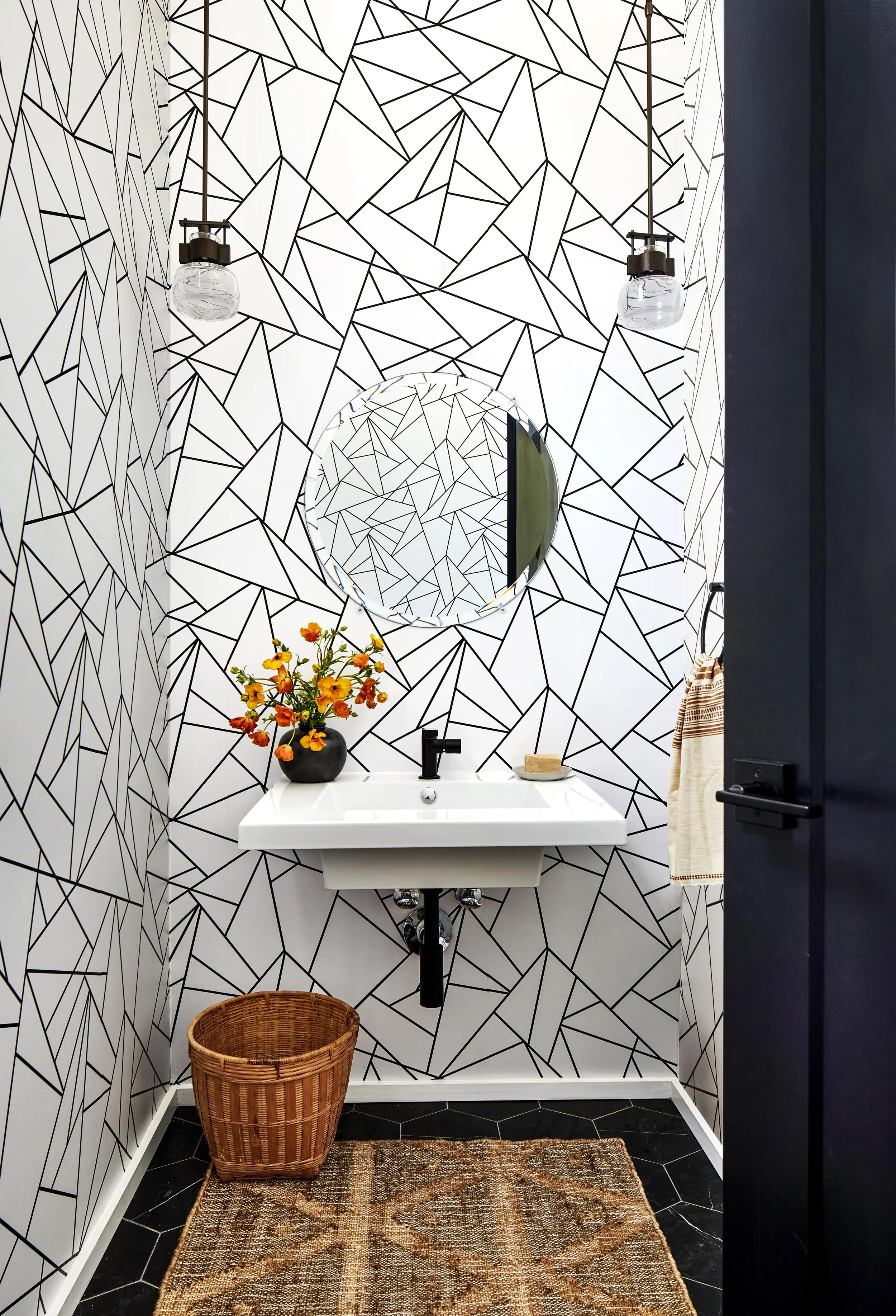Statement powder room in black and white with natural accents