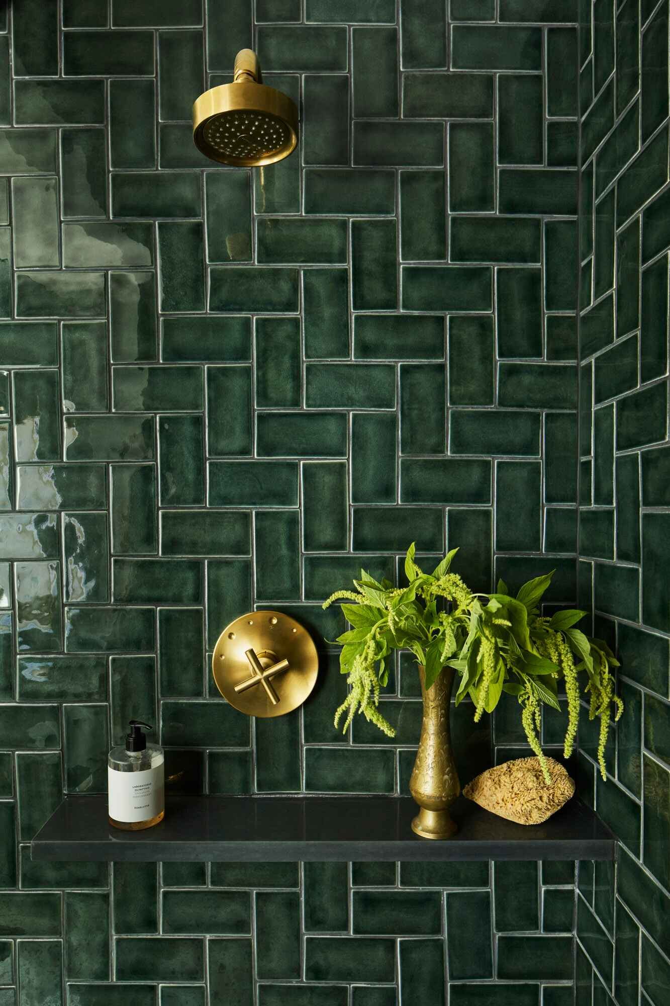 emerald green herringbone time and brass bathroom fixtures
