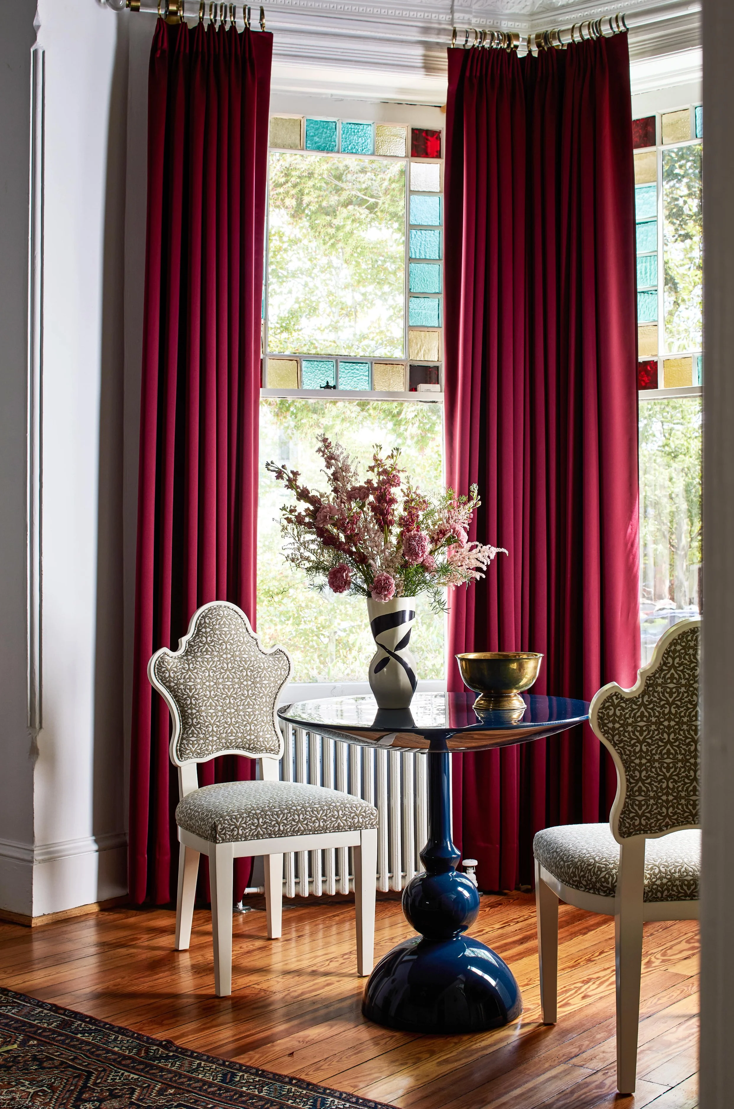 Stained-glass-bay-window-seating-ruby-drapes.jpg