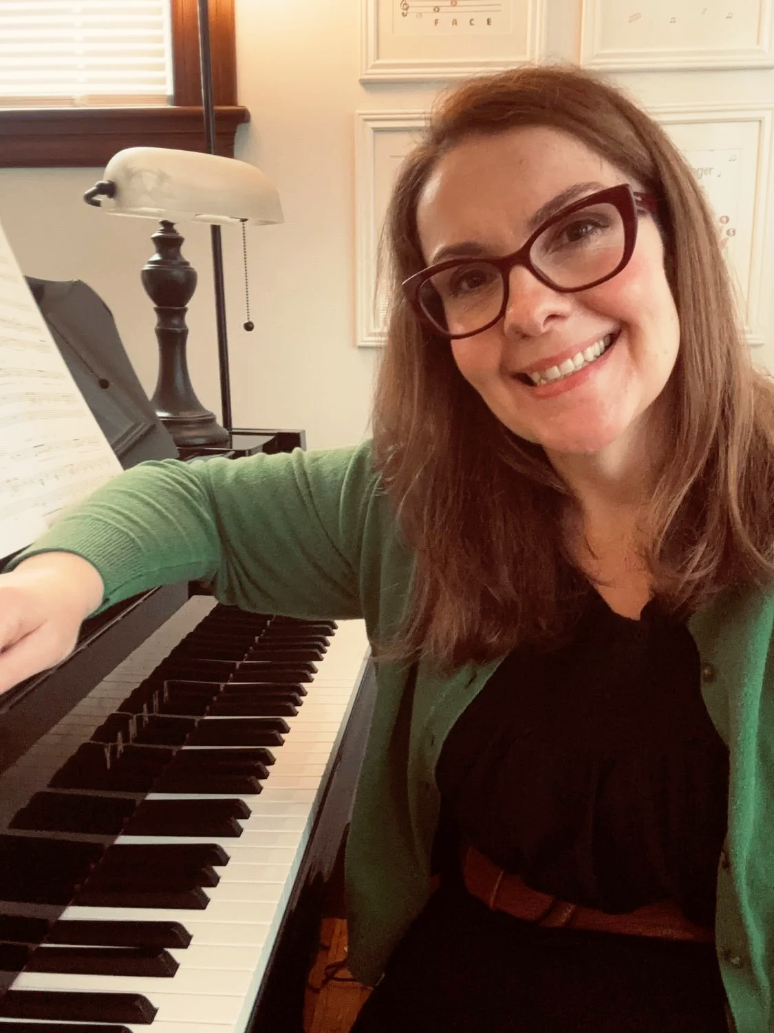 Katie Jillson, white female, vocal coach near Dedham, MA seated at the piano.