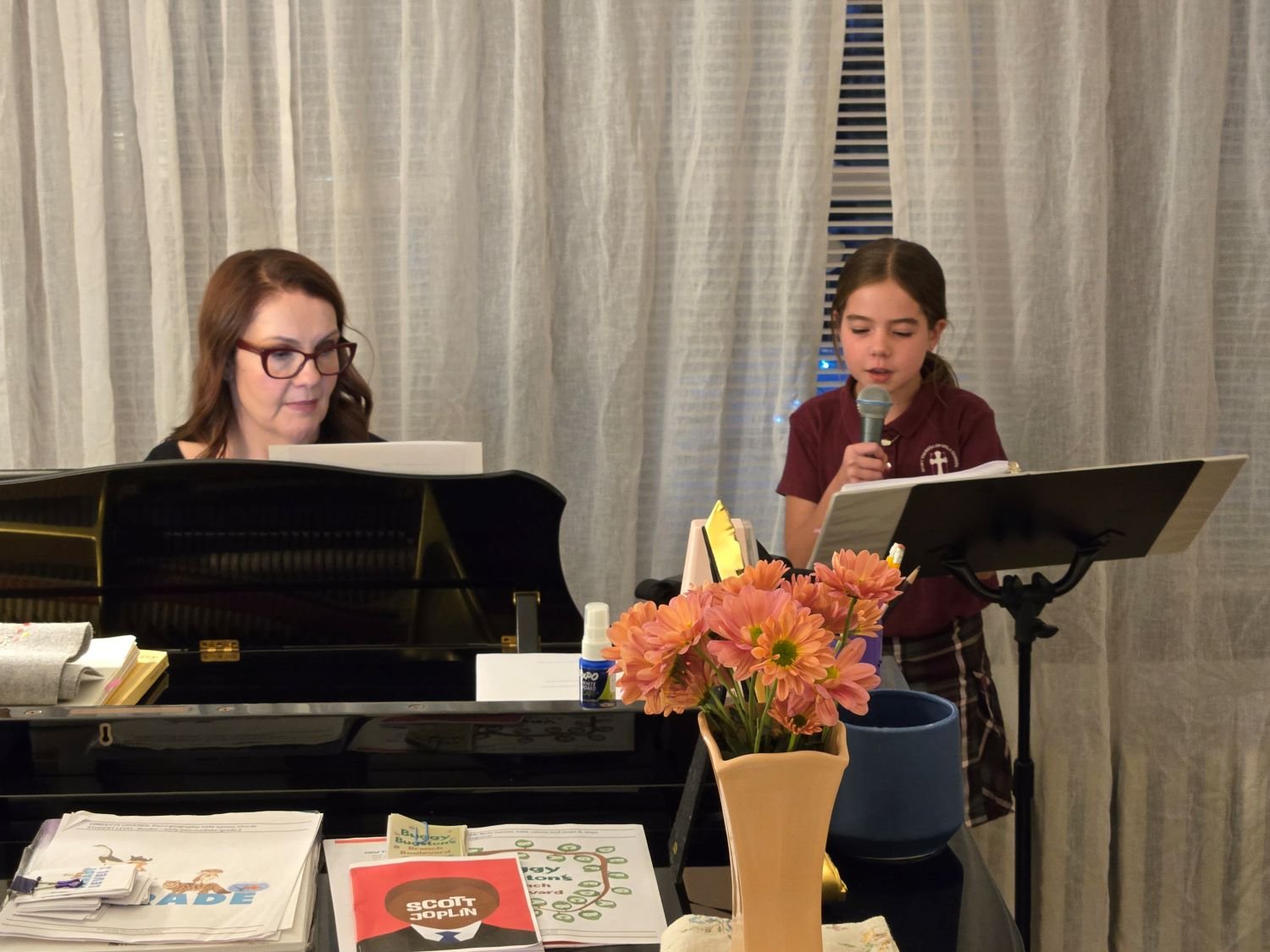 Katie Jillson, female, at piano teaching elementary-aged student singing lessons near Boston, MA.