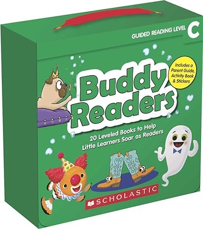 A green Scholastic Buddy Readers book set box with a red handle, featuring cartoon characters including a unicorn, a clown, and a friendly ghost, labeled for guided reading level C.