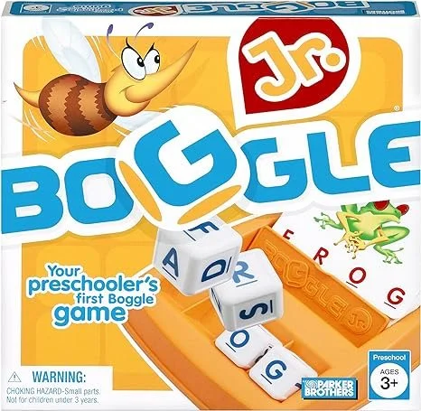 The image shows a children's board game called Jr. Boggle. It features a bright orange game board with white dice displaying letters. There is a cartoon bumblebee character flying above the game box, which has a playful font. The package indicates th