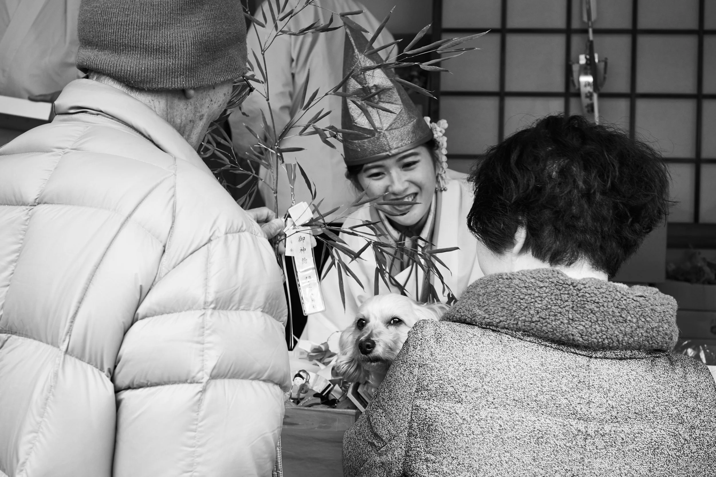 A Fukumusume talking with visitors during the sale of good luck amulets.