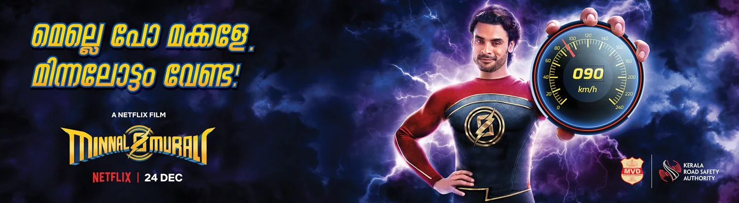 Promotional poster for the Netflix film "Minnal Murali" featuring a superhero character holding a speedometer showing 090 km/h with stormy, electric background. Includes text in Malayalam and logos for MVD and Kerala Road Safety Authority. Release da