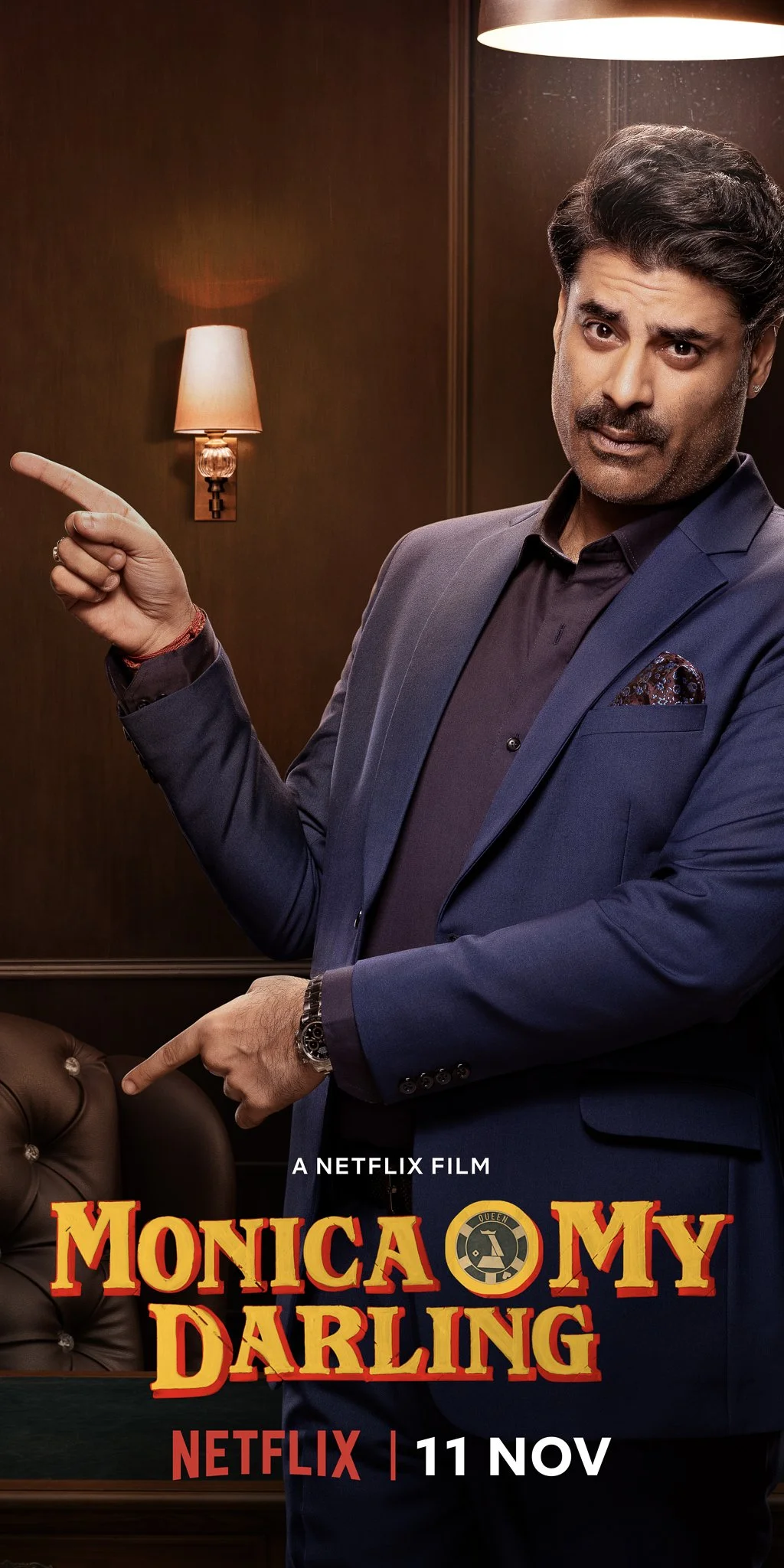 Promotional poster for the Netflix film "Monica, My Darling," featuring a man in a blue suit pointing with both index fingers. Release date: November 11 on Netflix. Background includes a wall lamp and a round lampshade.