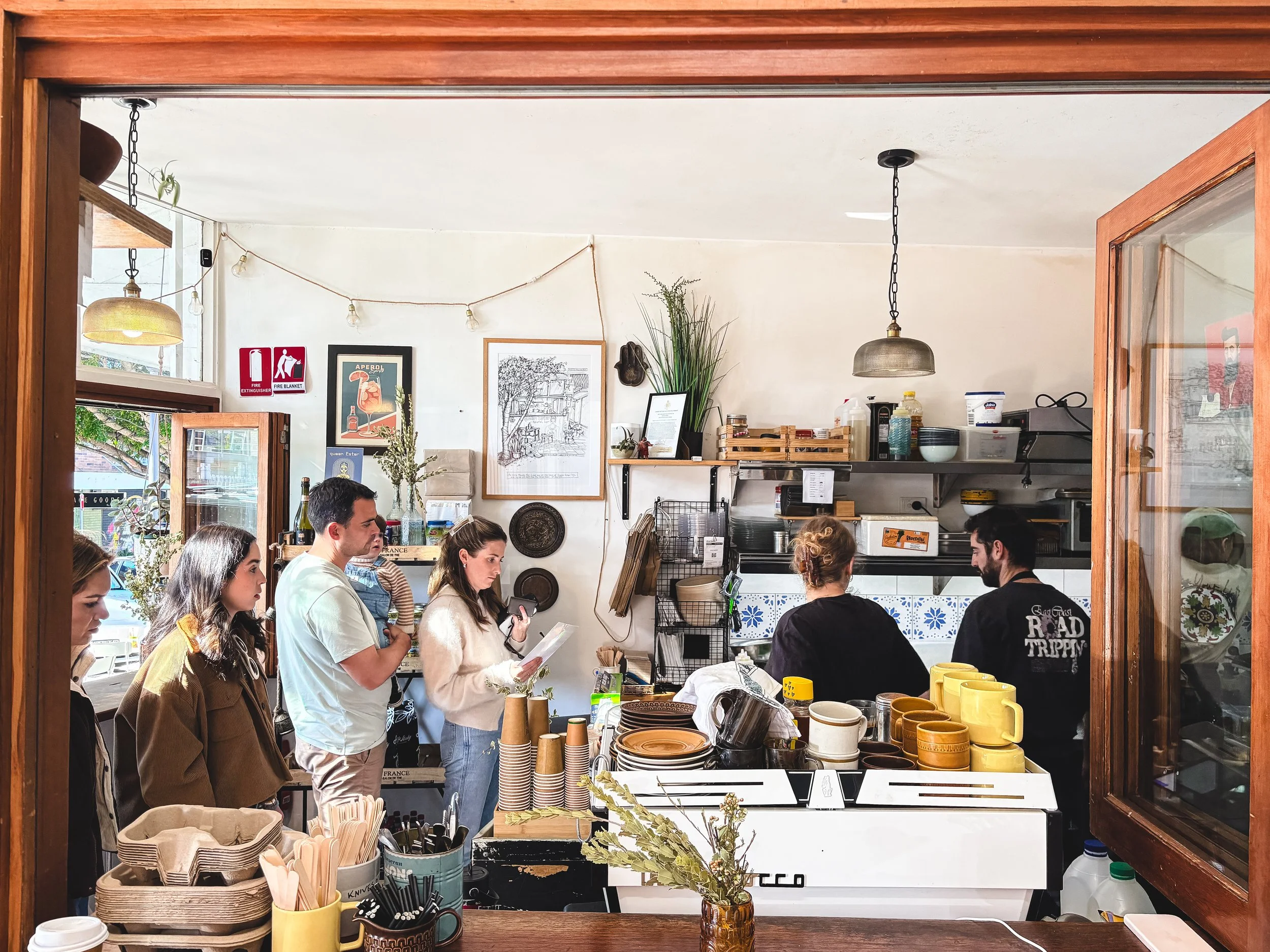 side window view of queen ester falafel bar, coffee machine and costumers 