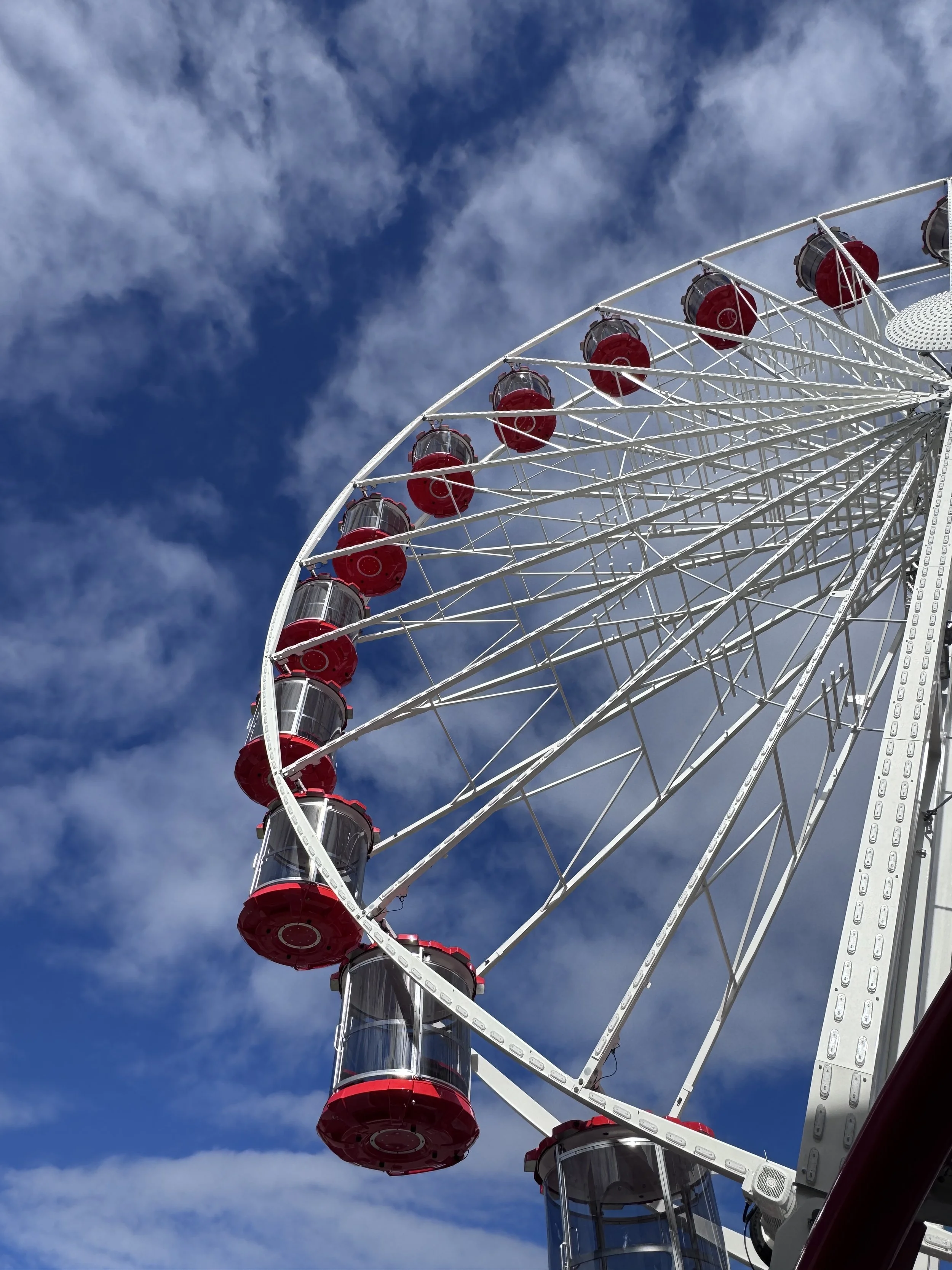 Giant Wheel in the day time with red gondola