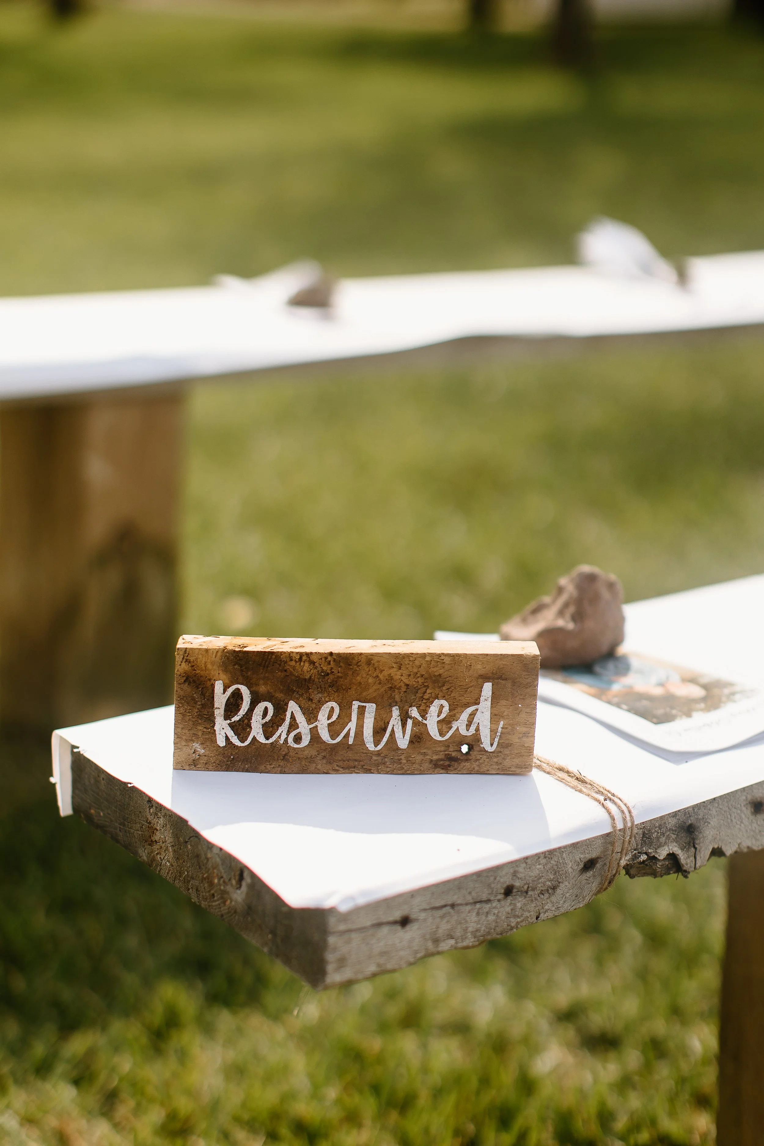 Wooden table with a 'Reserved' sign at an outdoor ceremony at a wisconsin barn wedding venue