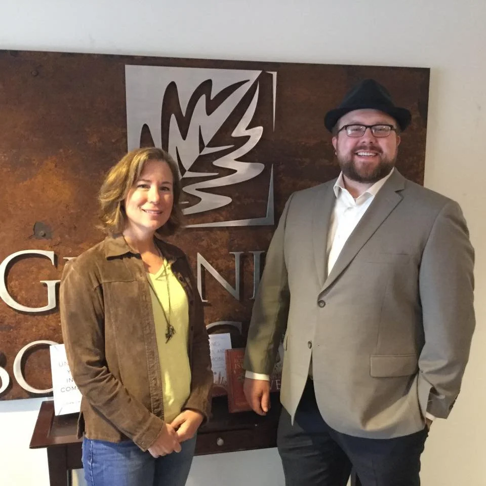 Business book ghostwriter Derek Lewis (right) standing with a Greenleaf Book Group acquisitions executive in front of their office logo, demonstrating direct publishing industry connections.