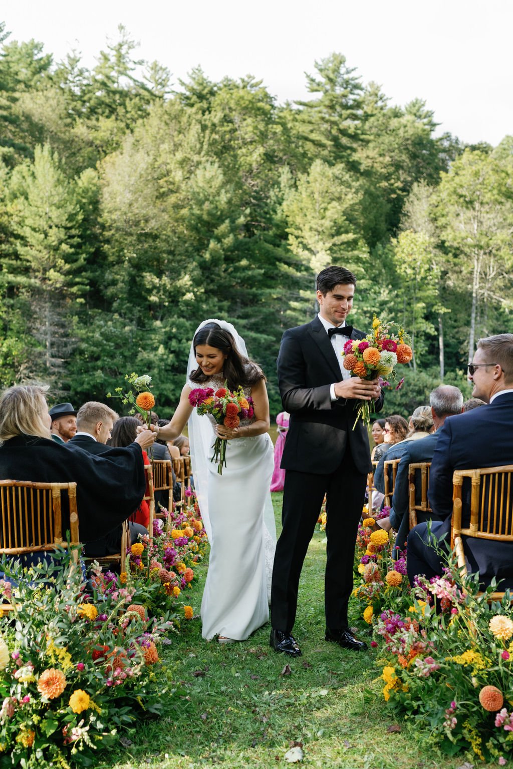  Guests help the bride and groom create a bridal bouquet with flowers during the ceremony 