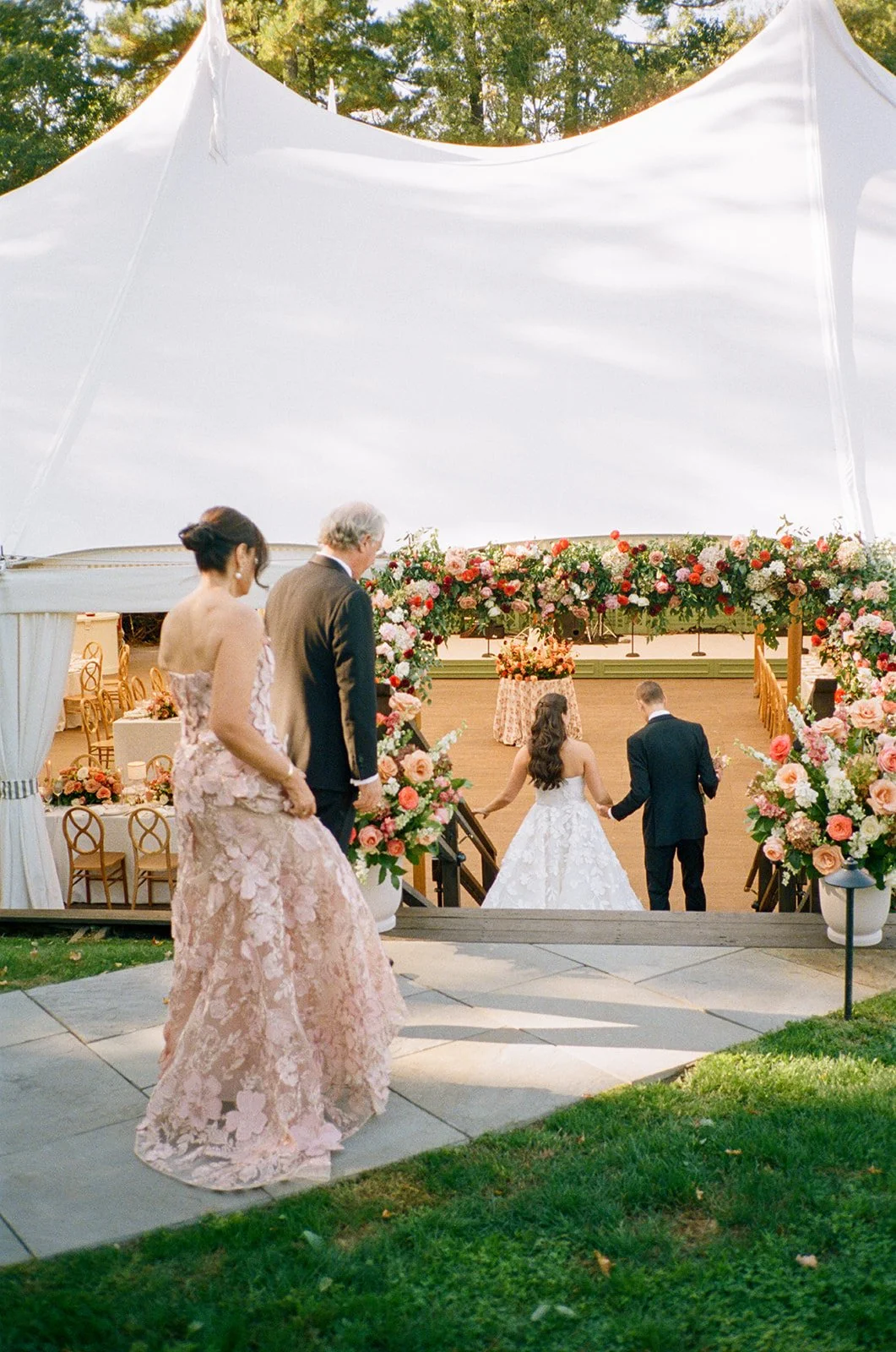A bride and groom enter their sailcloth tented wedding reception in Connecticut