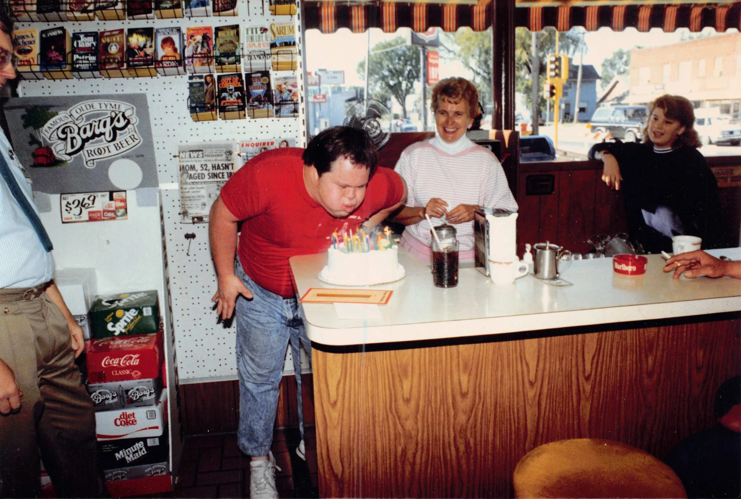 St. Paul Corner Drug legend, J.R., blows out the candles on his birthday cake