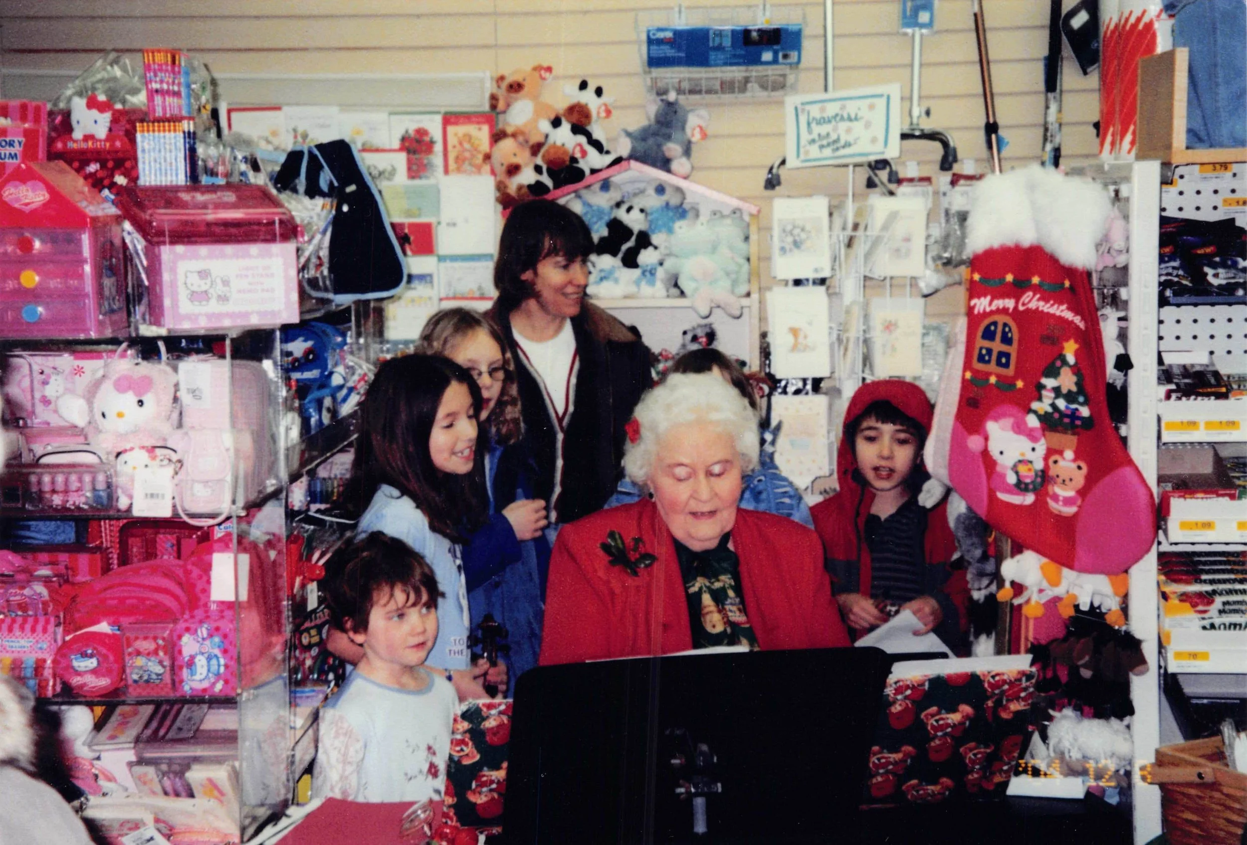 Melba and the kids sing carols at the store's once-annual holiday party