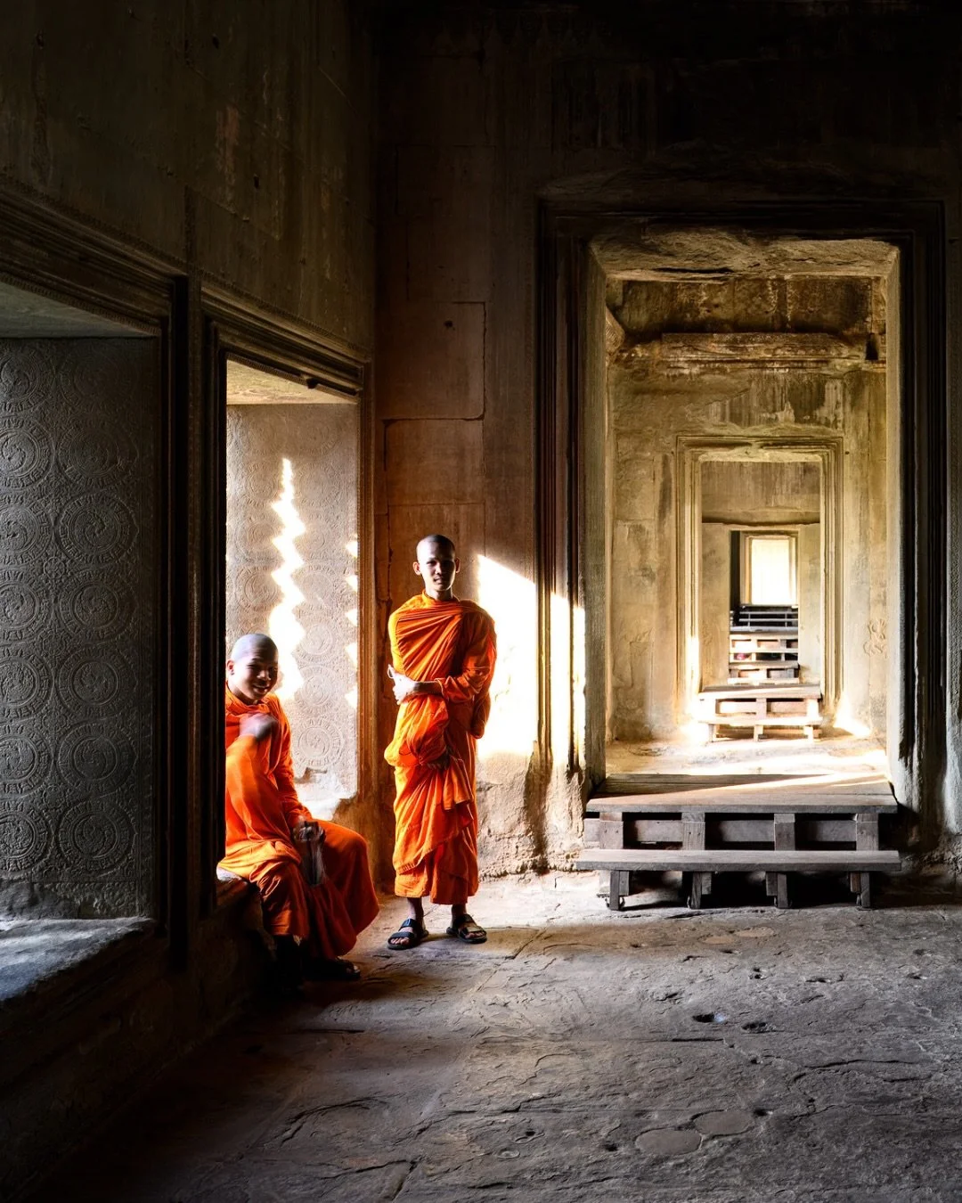 📷 Memory in Moment Exhibit
&ldquo;Young Monks at Siem Reap Temple&rdquo; by James Lynxwiler

Light spills through ancient stone as two young monks pause in quiet ease &mdash; a moment suspended between play and devotion, where history and youth gent