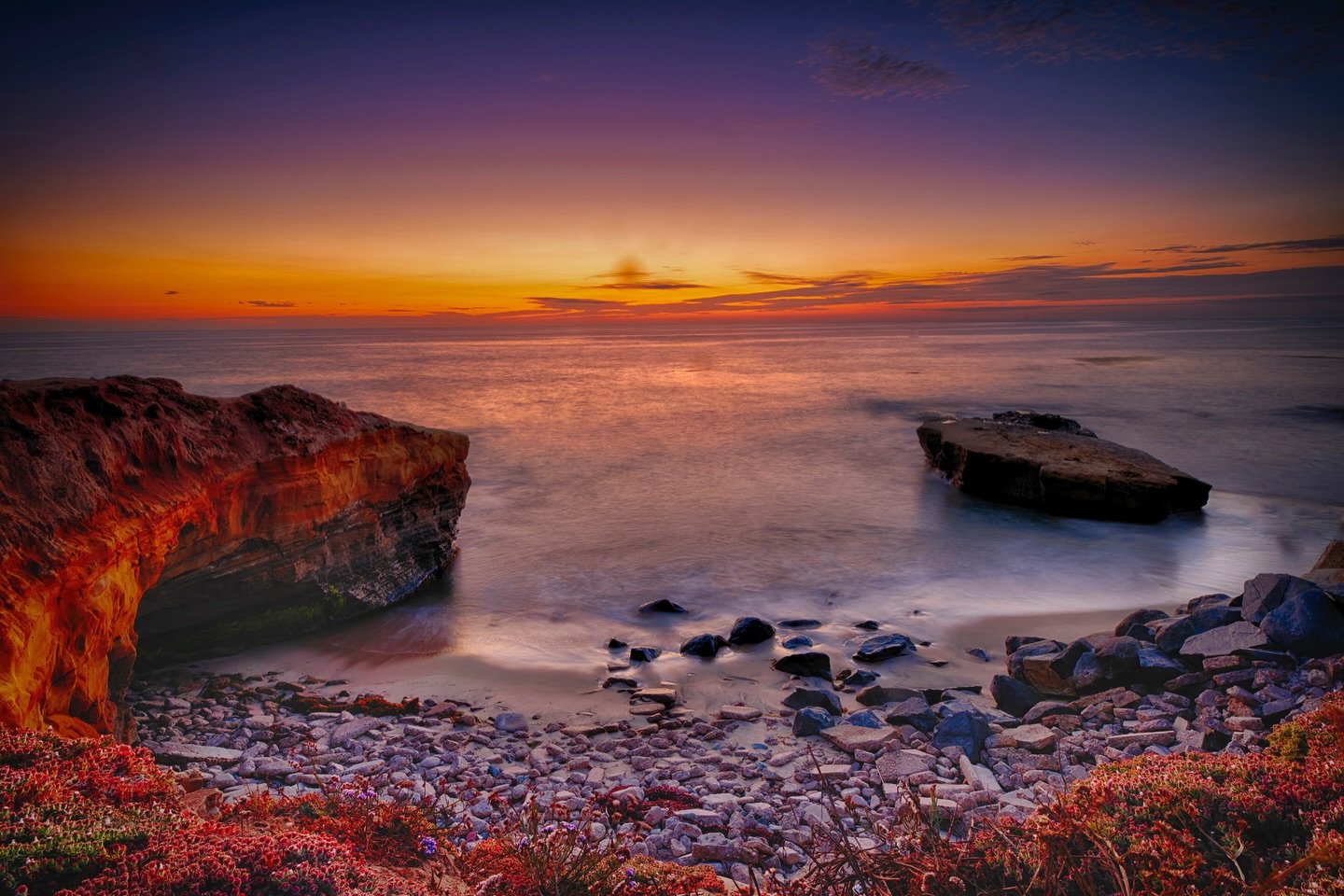 📷 Heat and Light Exhibit
&ldquo;Azure Sunset&rdquo; by Doreen McGunagle &mdash; Honorable Mention

As the sun slips below the horizon, sky and sea dissolve into layers of fire and calm. Warm hues wash over stone and water, while the long exposure so