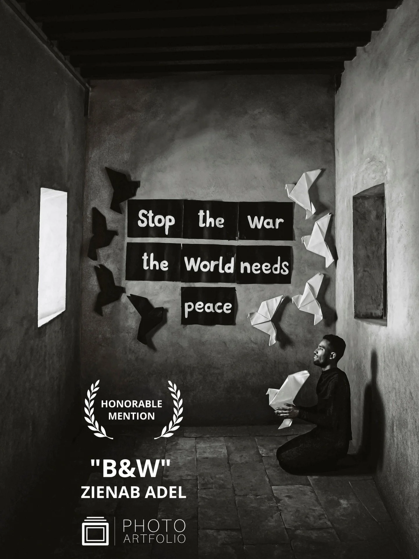 📷 B&amp;W: The Poetry of Light &amp; Shadow
Honorable Mention
&ldquo;The Power of Peace&rdquo; by Zienab Adel (@zienabadel1) 

In a quiet room, a single gesture becomes a statement. Words on the wall call for peace, while folded birds rise in silent
