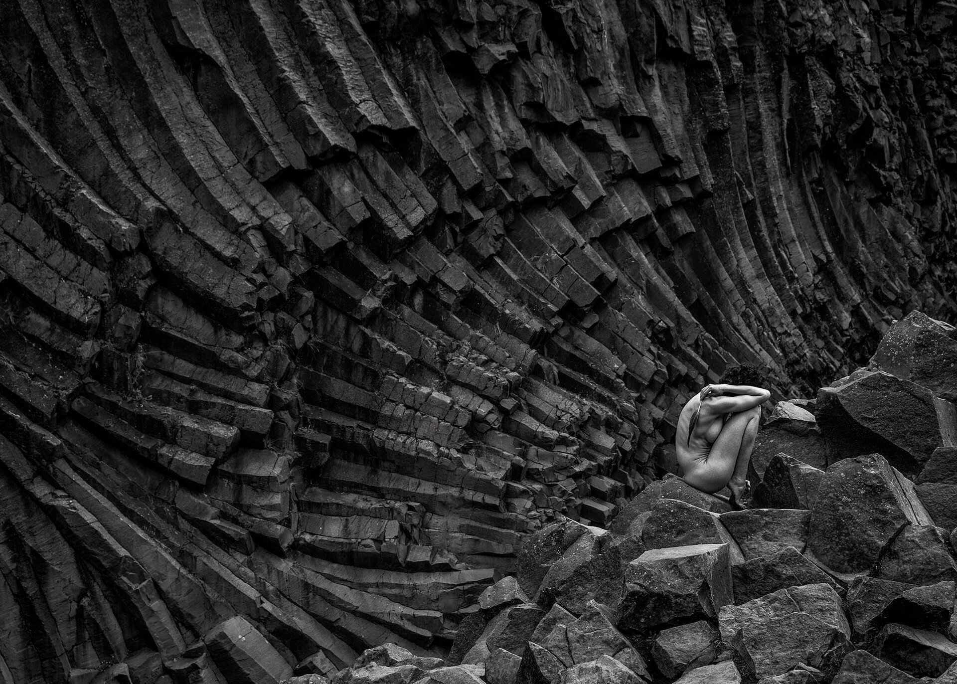📷 B&amp;W: The Poetry of Light &amp; Shadow
&ldquo;Untitled (V and the Barrage of Stone)&rdquo; by Michael Potts (@mrp_visionaries)

A solitary figure folds into itself, suspended within a landscape of fractured stone. The body becomes both refuge a