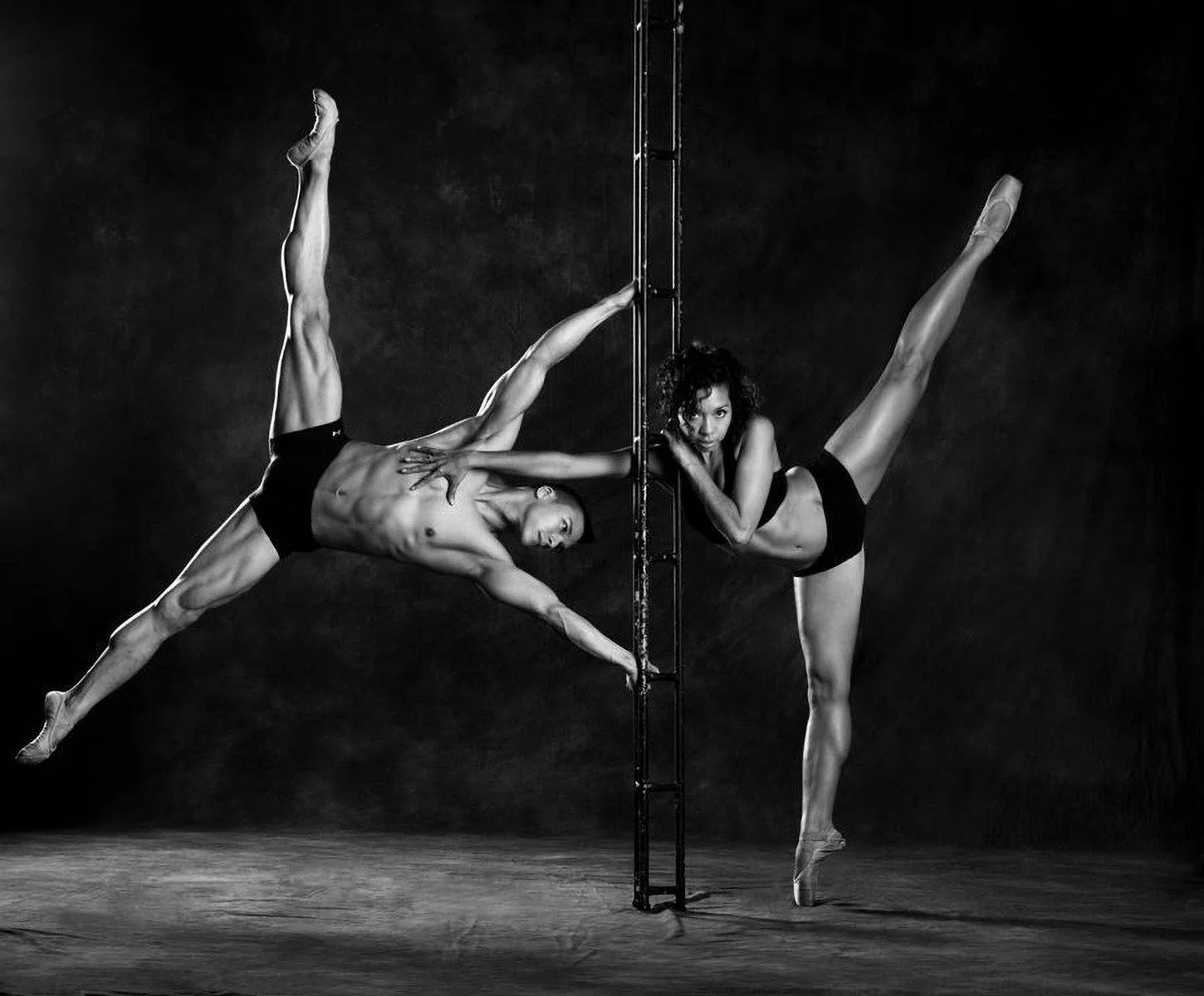 📷 B&amp;W: The Poetry of Light &amp; Shadow
&ldquo;Dynamic Tension&rdquo; by Kevin Roberts (@kevinrobertsintimateimages)

Bodies extend into impossible geometry &mdash; strength suspended between balance and surrender. The vertical axis becomes both