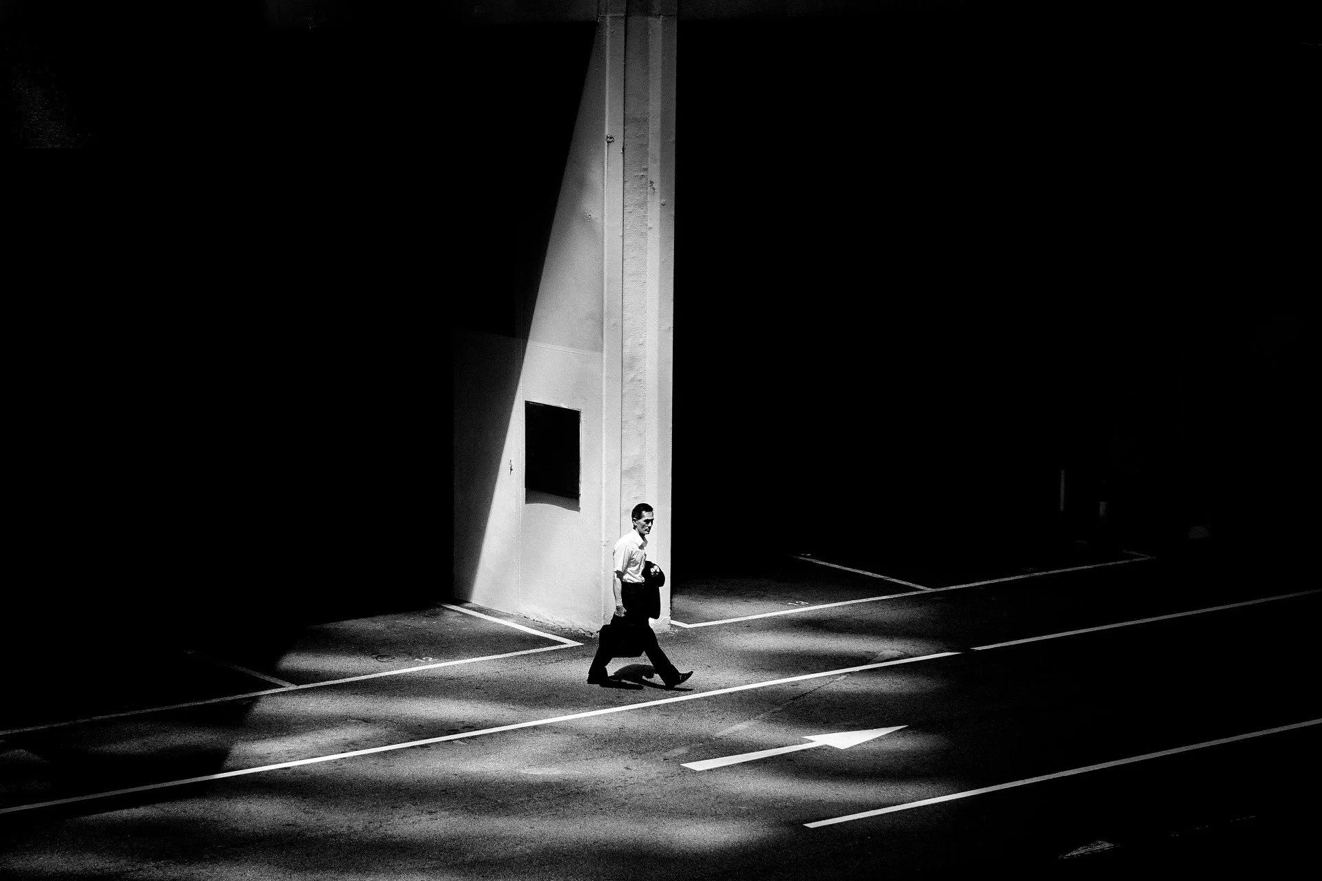 📷 B&amp;W: The Poetry of Light &amp; Shadow
&ldquo;Spotlight&rdquo; by Lawrence Cheung @lawrence_cheung_photography 

A single beam defines the stage &mdash; not chosen, but crossed. The figure steps through illumination as geometry frames the momen