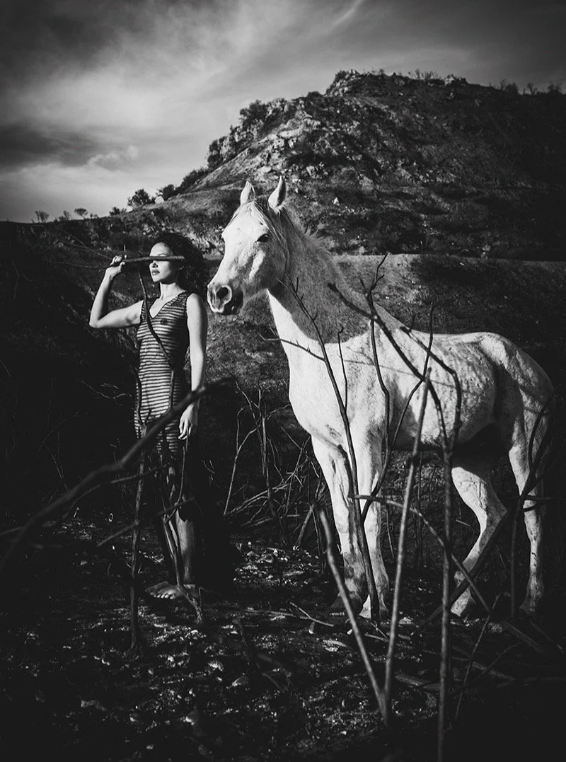 📷 B&amp;W: The Poetry of Light &amp; Shadow
&ldquo;Blind Faith&rdquo; by Jill Sutherland (@jillsutherlandphoto) 

A woman stands beside a white horse, her eyes covered as she faces the open landscape. The gesture suggests trust, intuition, and the q
