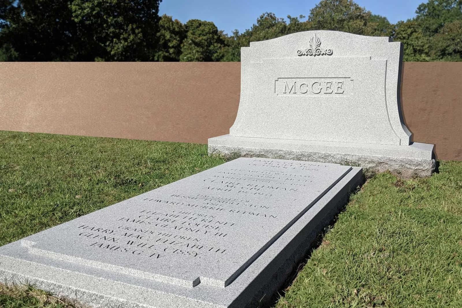 Gravestone with the name "McGee" engraved on it, surrounded by grass with trees in the background.